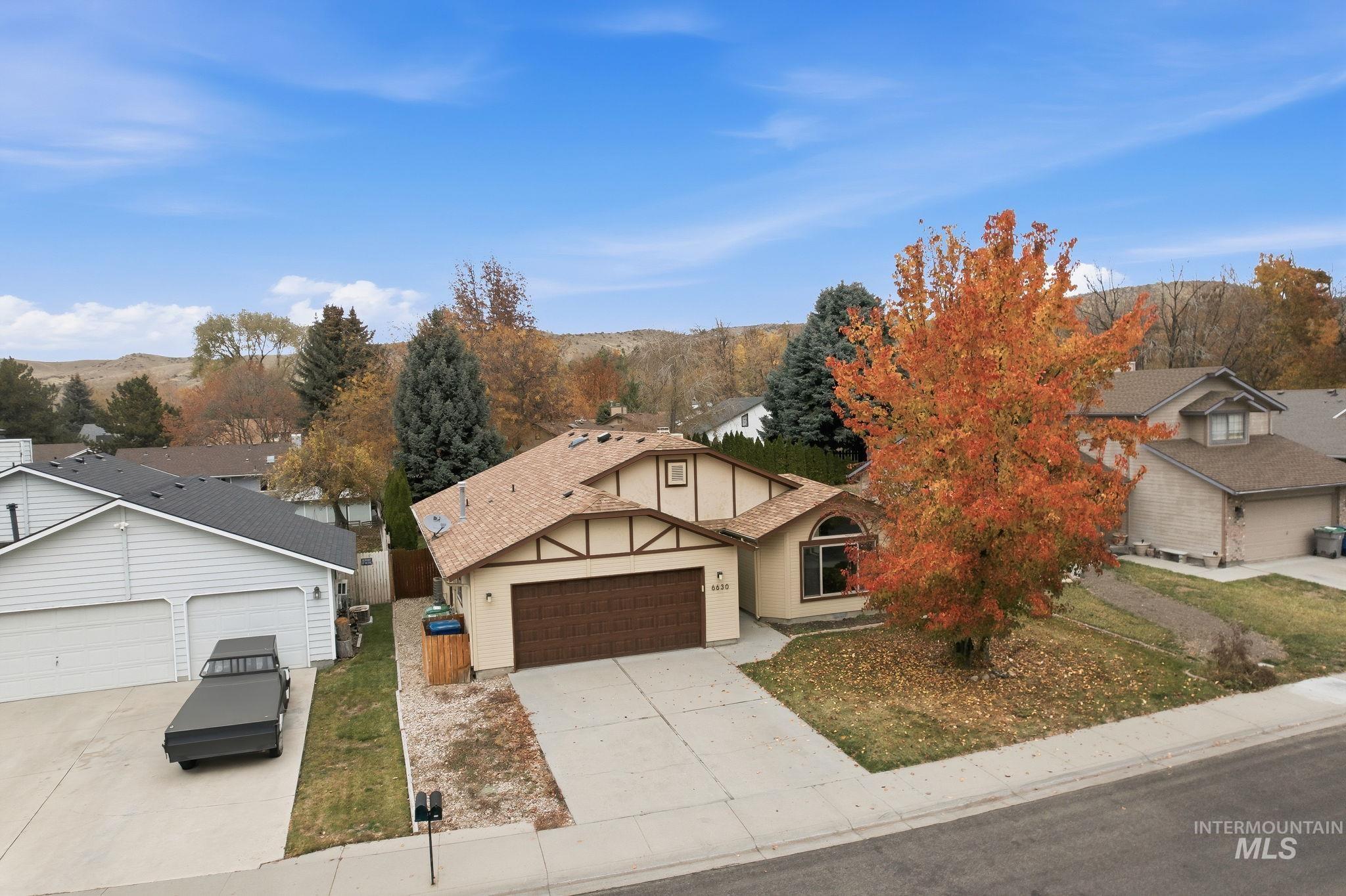 View of front of home featuring concrete driveway, an attached garage, and a shingled roof