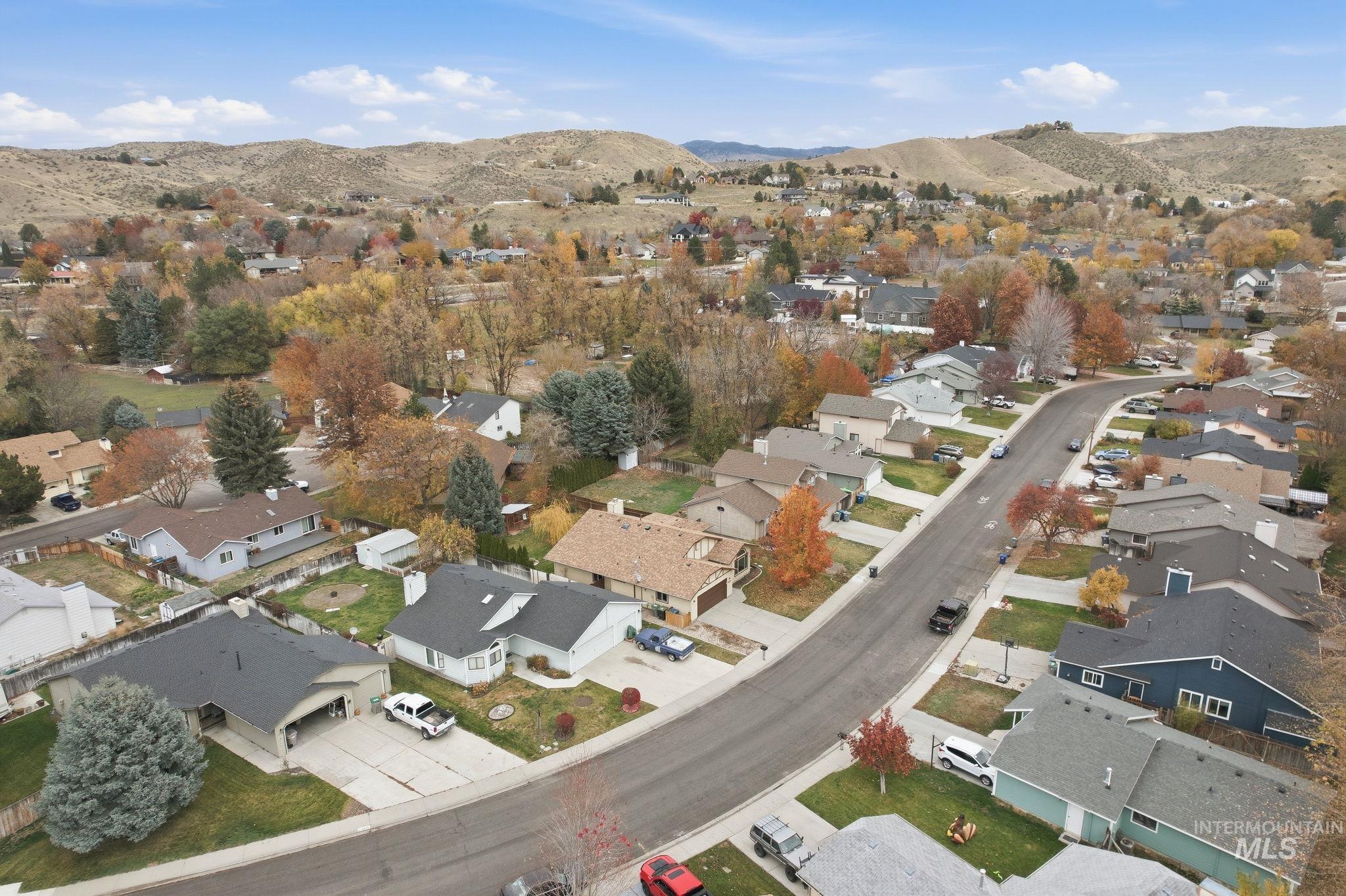 Aerial view of property's location with a mountain backdrop and nearby suburban area