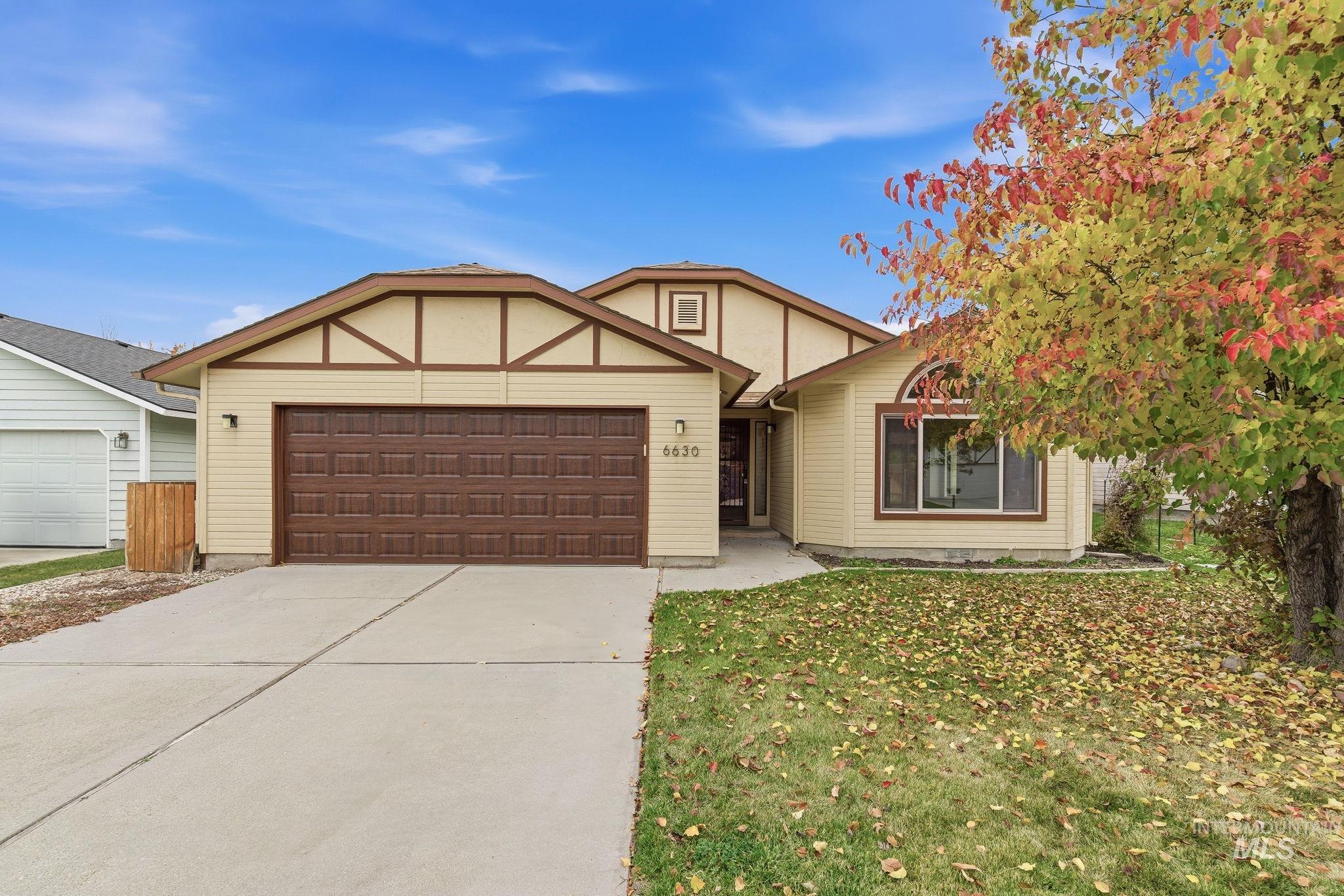 View of front of house with driveway, a garage, and a front yard
