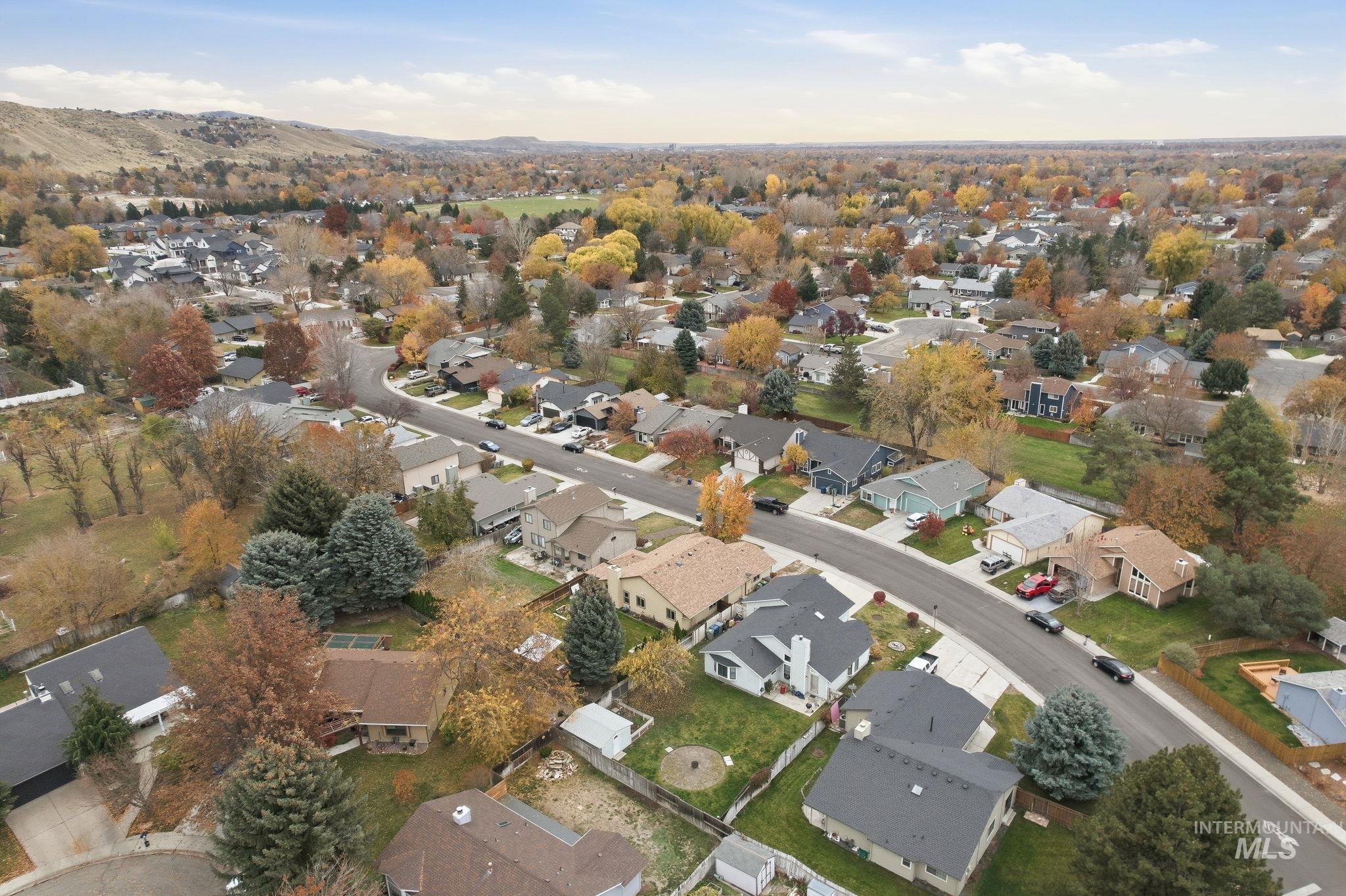 Aerial view of property and surrounding area featuring nearby suburban area