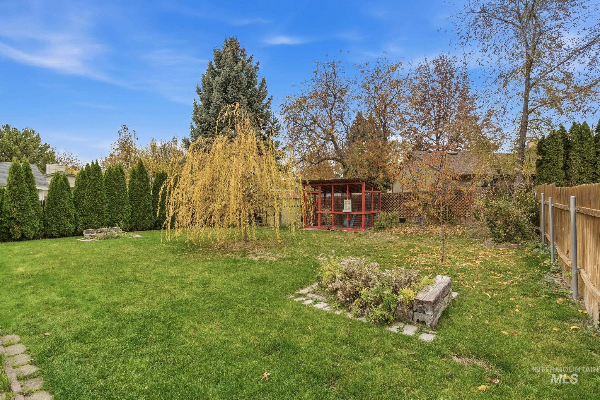 Fenced backyard featuring an outbuilding and exterior structure