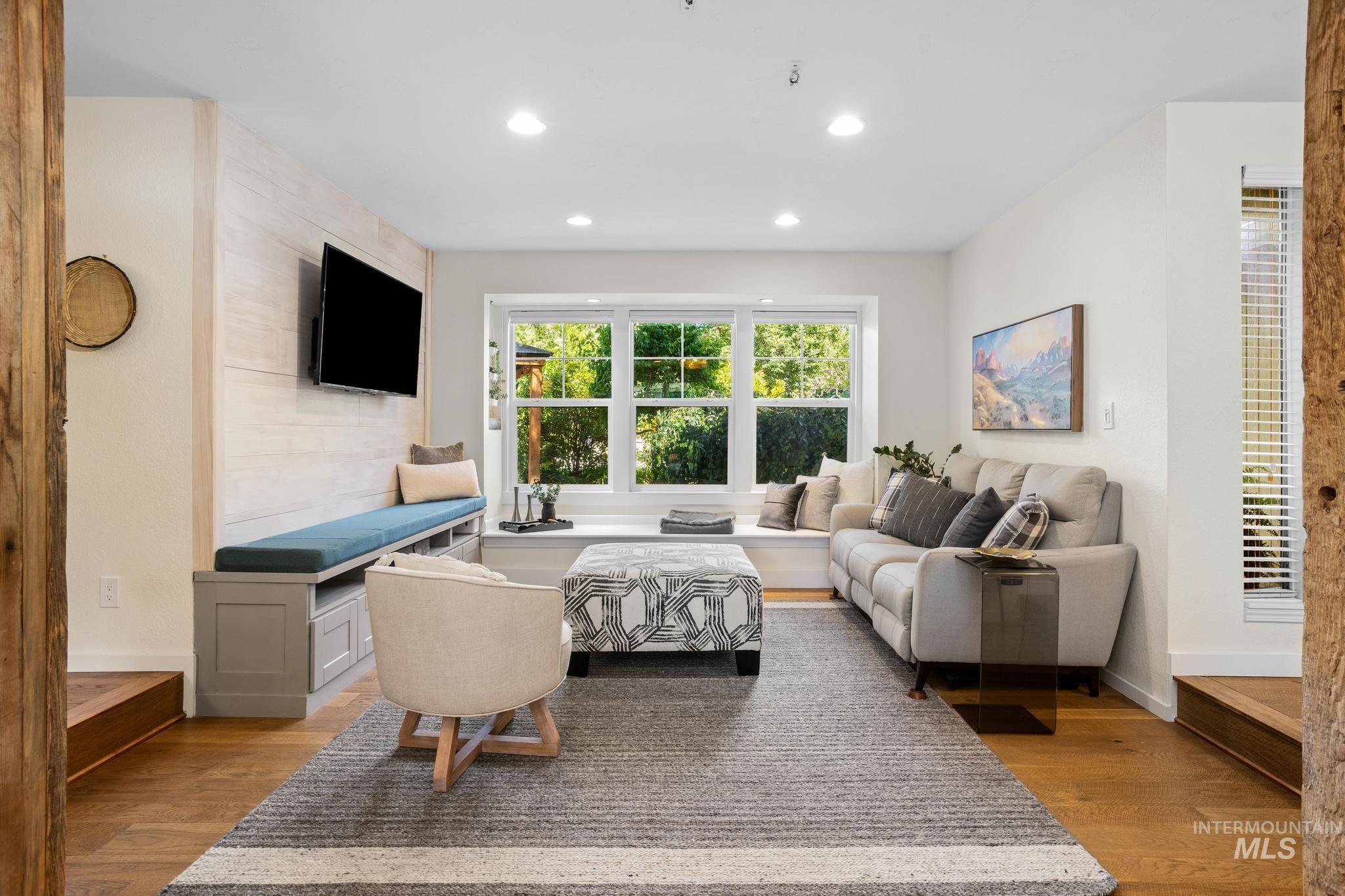 Spacious living area featuring wood-finish flooring, recessed lighting, and a window bench with built-in storage