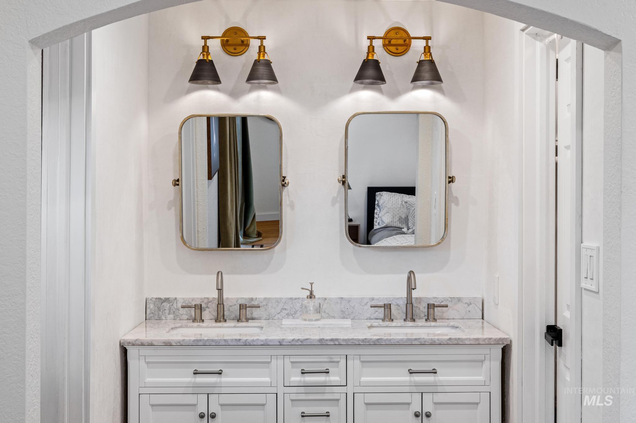 Dual vanity with white cabinetry, brushed nickel hardware, and a light-toned countertop