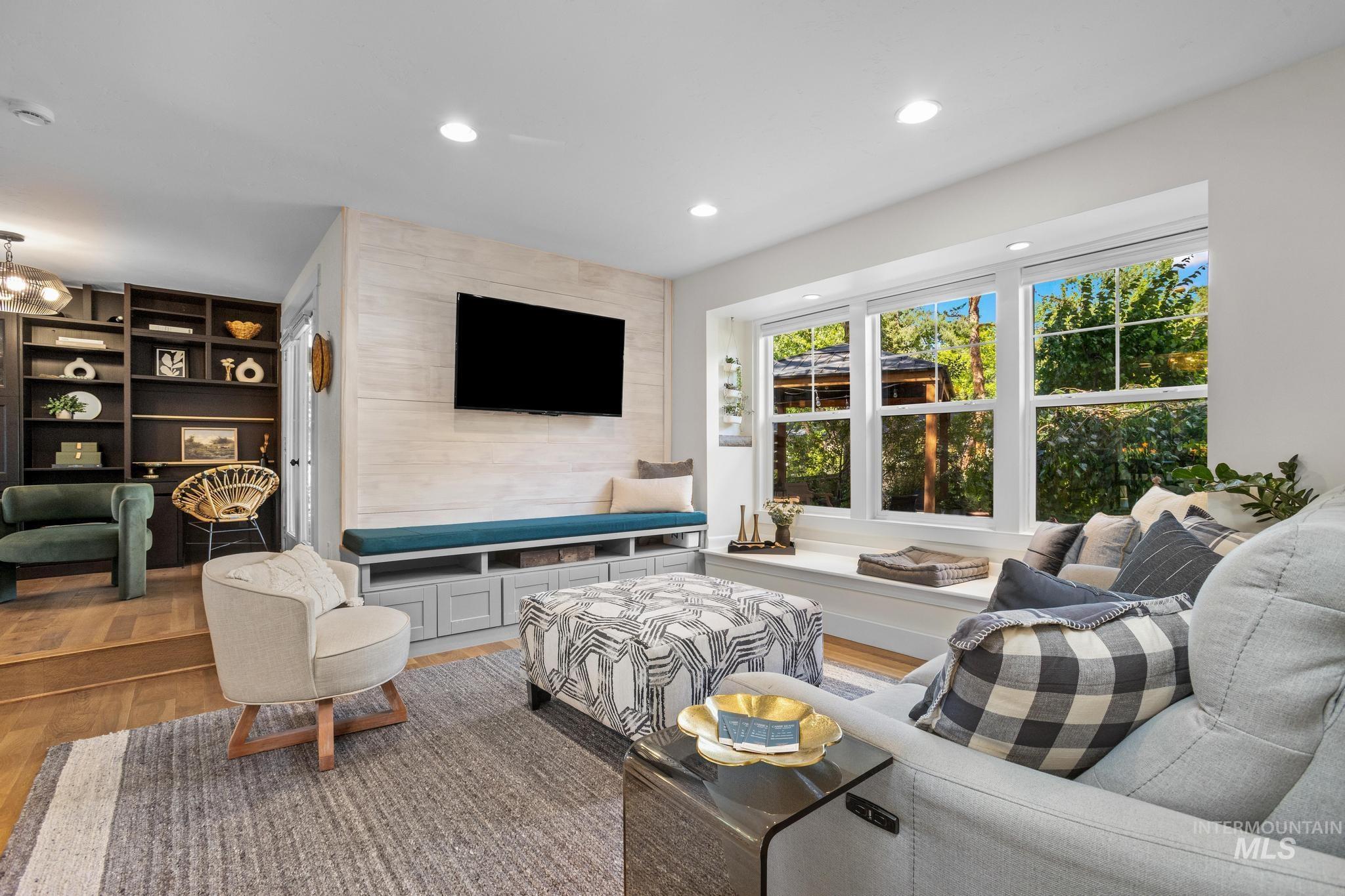 Spacious living area featuring a large bay window, built-in window seating, and recessed lighting