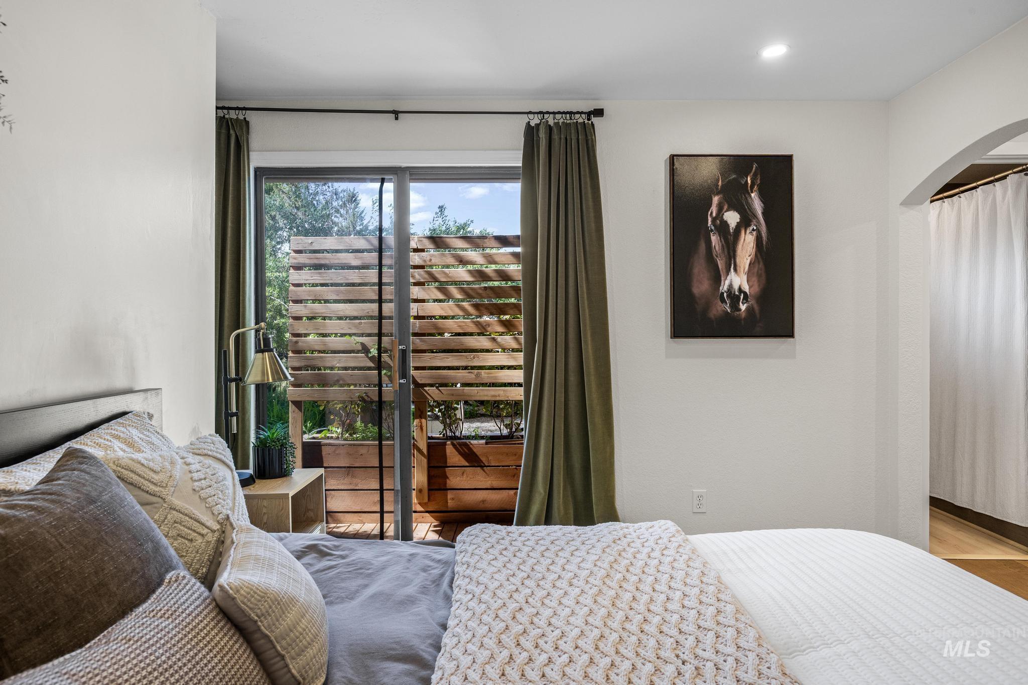 Sliding glass door opening to a private balcony with a wooden privacy screen