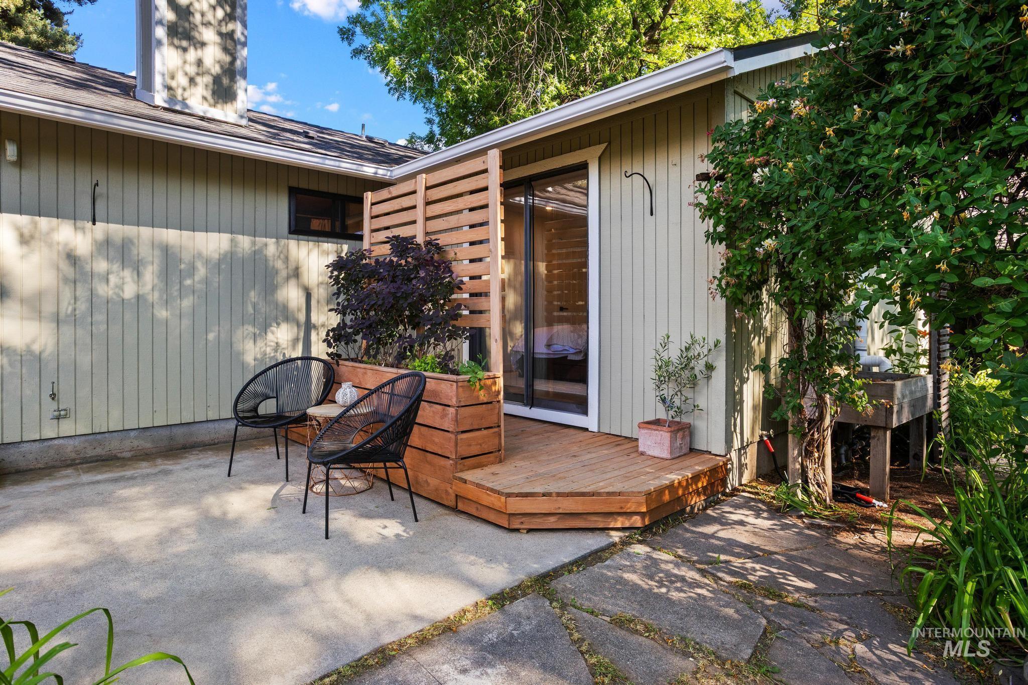 Outdoor patio featuring a wooden deck with a privacy screen and built-in planter