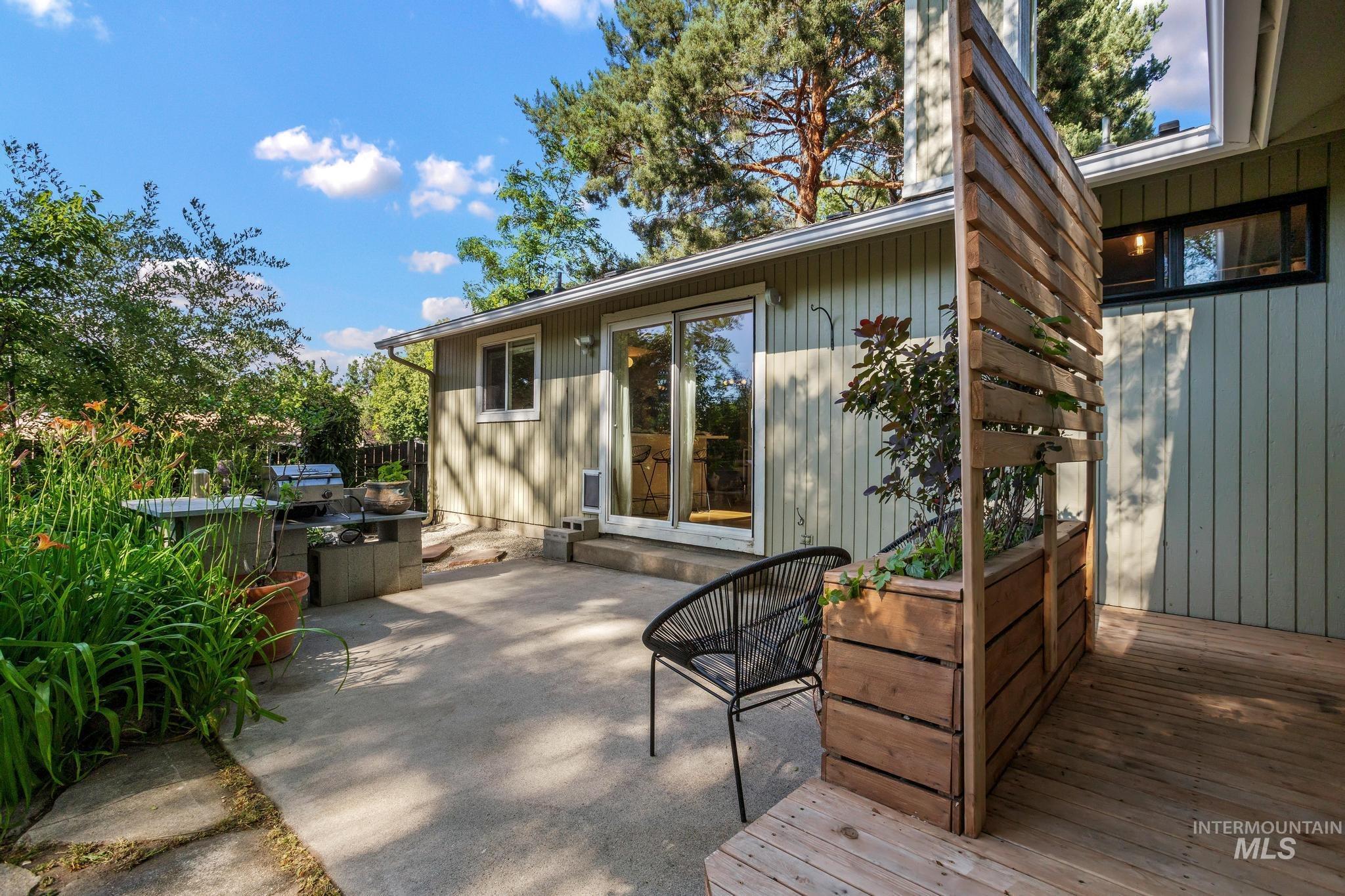 Expansive outdoor space featuring a concrete patio and wood deck