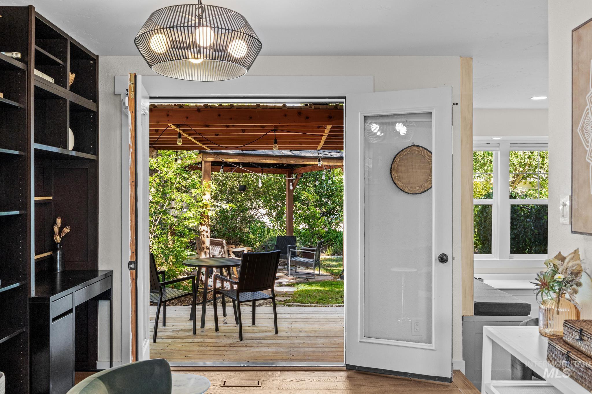 Interior space opening to an outdoor patio with a pergola