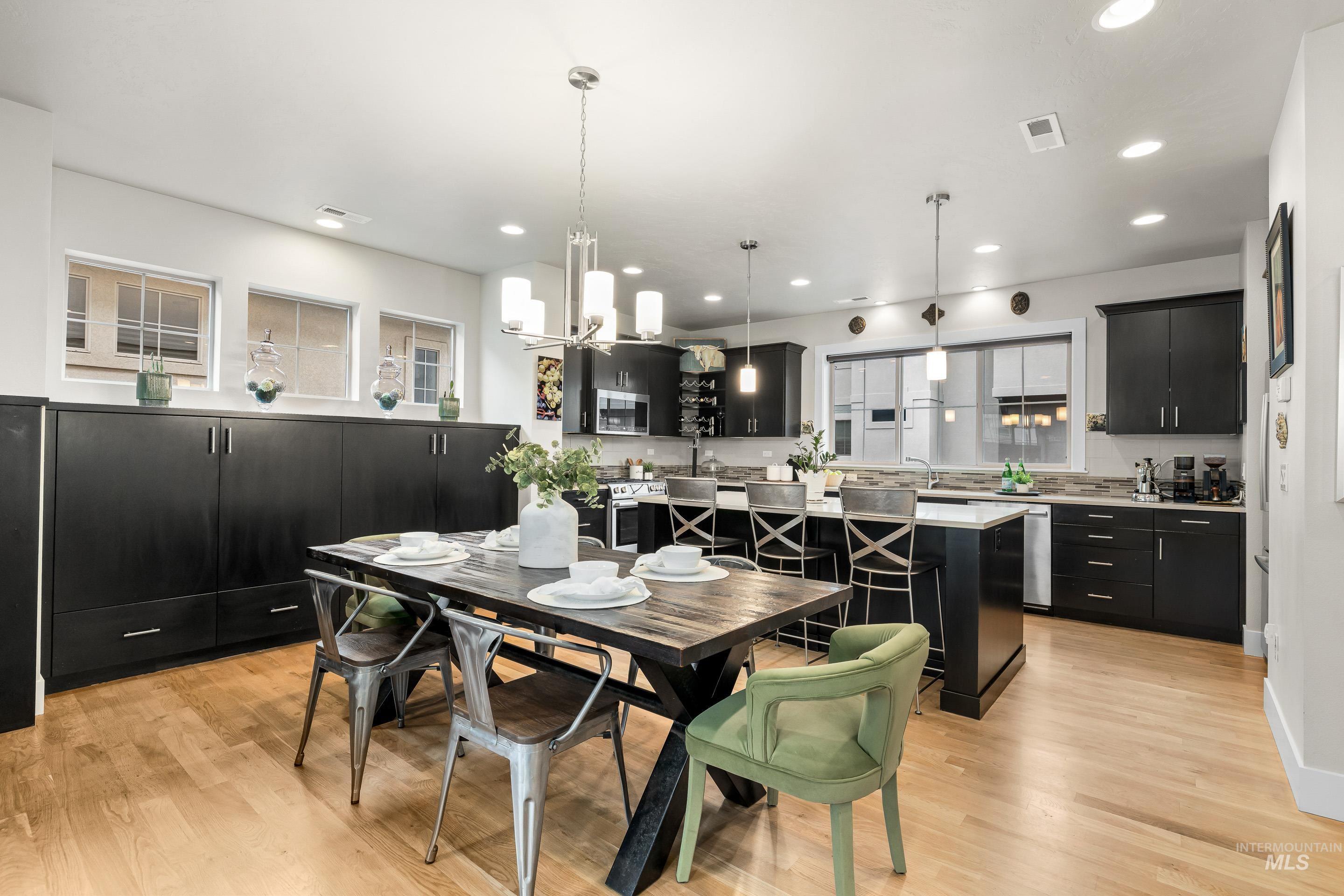 Dining room with light wood-style floors, a chandelier, and recessed lighting