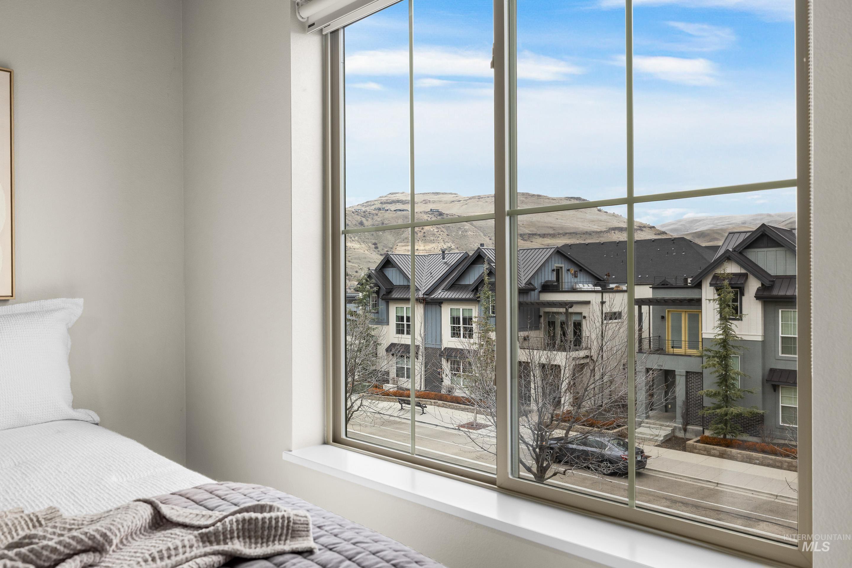 Bedroom featuring multiple windows, a mountain view, and a residential view