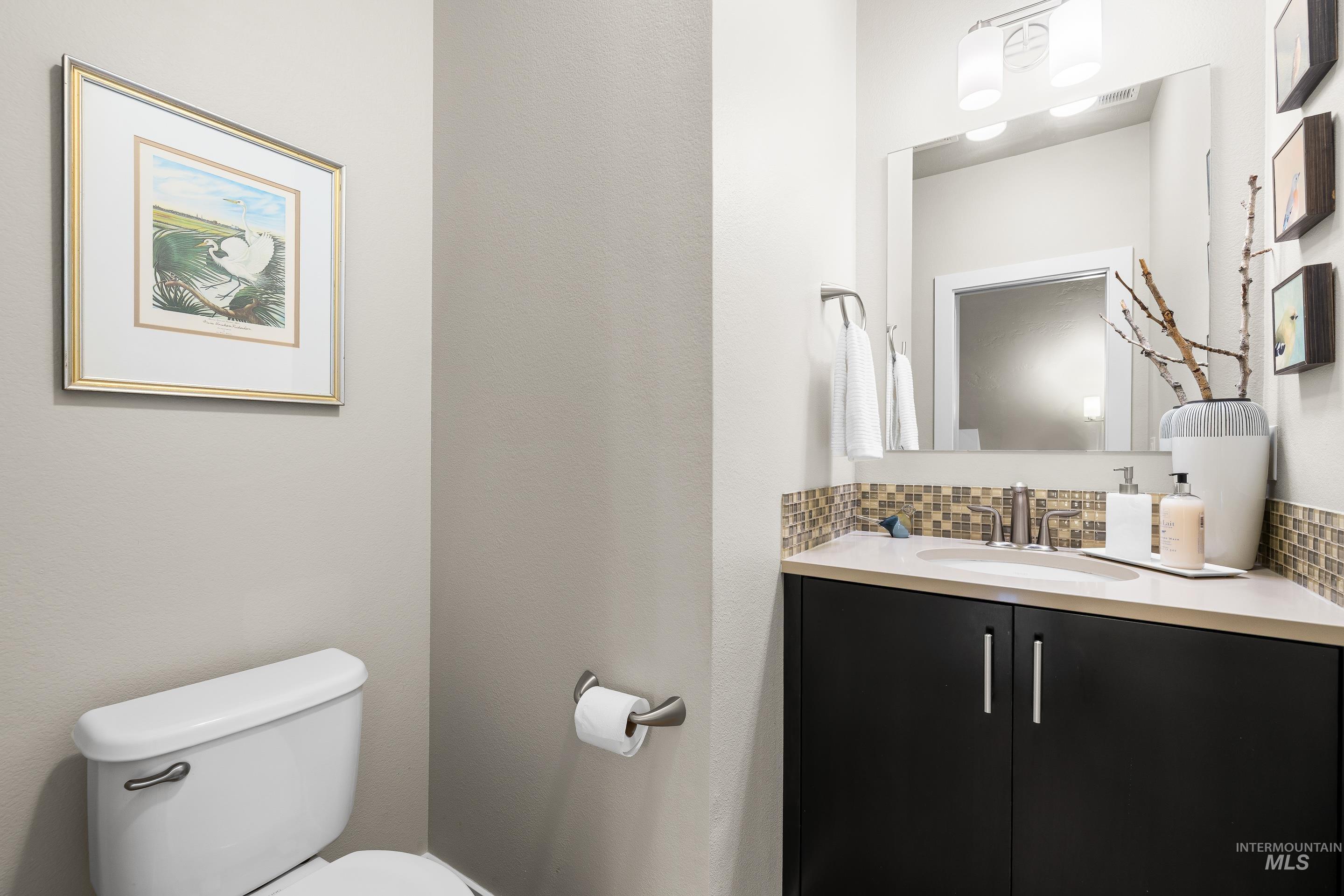 Bathroom with vanity and decorative backsplash