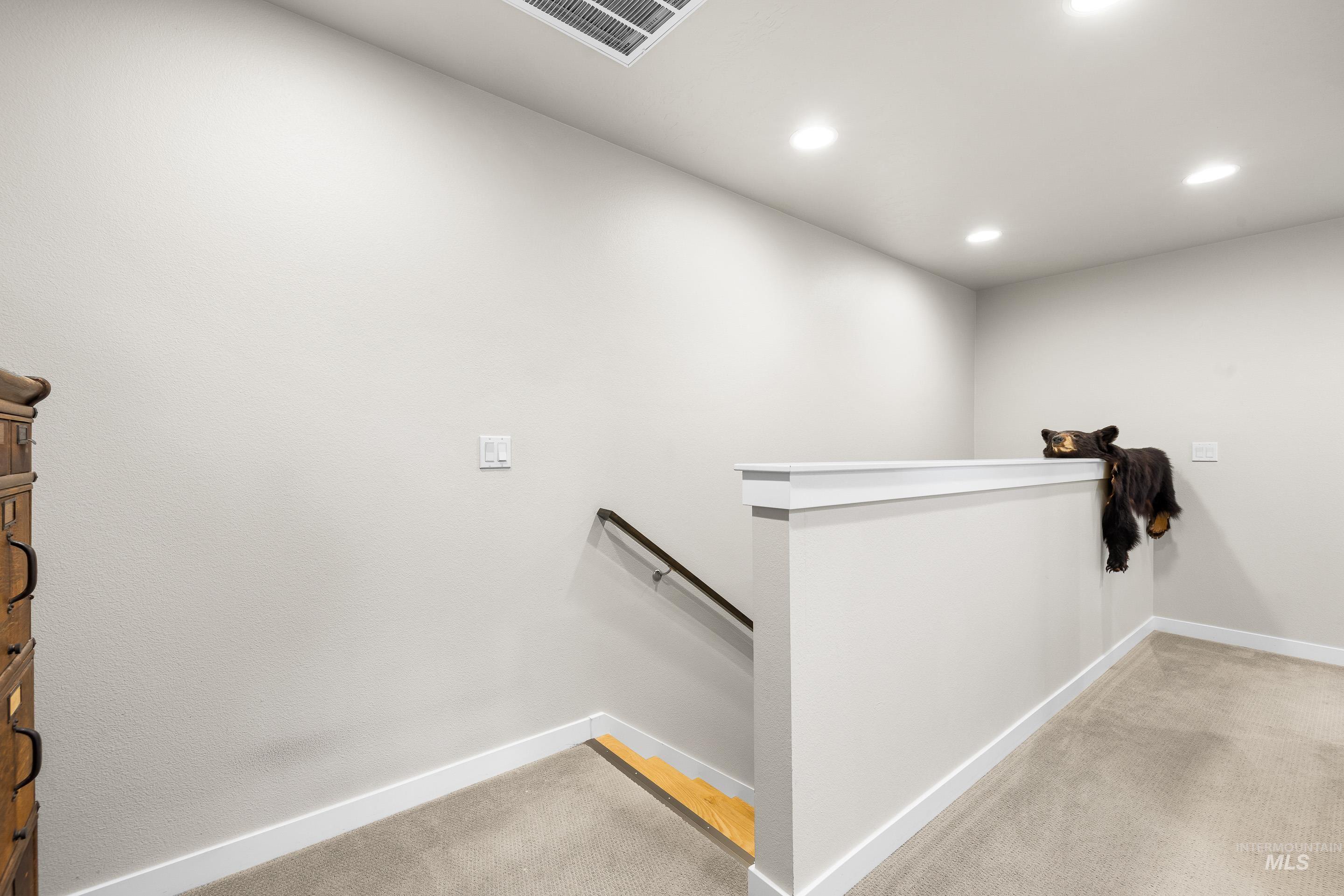 Stairway with carpet floors and recessed lighting