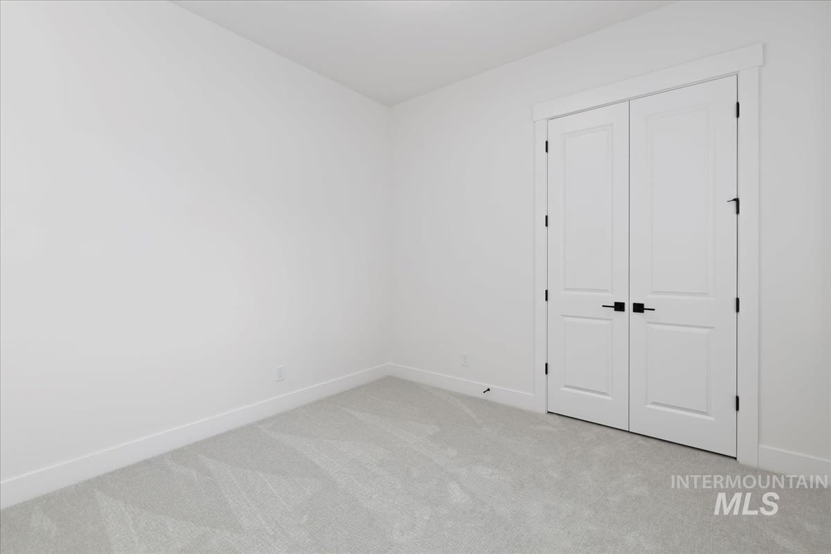Unfurnished bedroom featuring light colored carpet and a closet