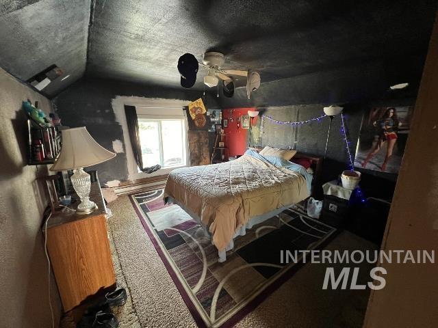 Bedroom featuring vaulted ceiling, carpet floors, and a textured ceiling