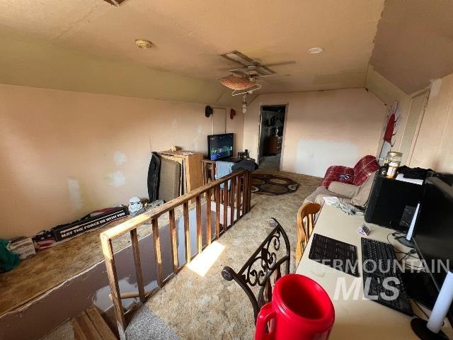 Interior space featuring an upstairs landing, a ceiling fan, and carpet floors