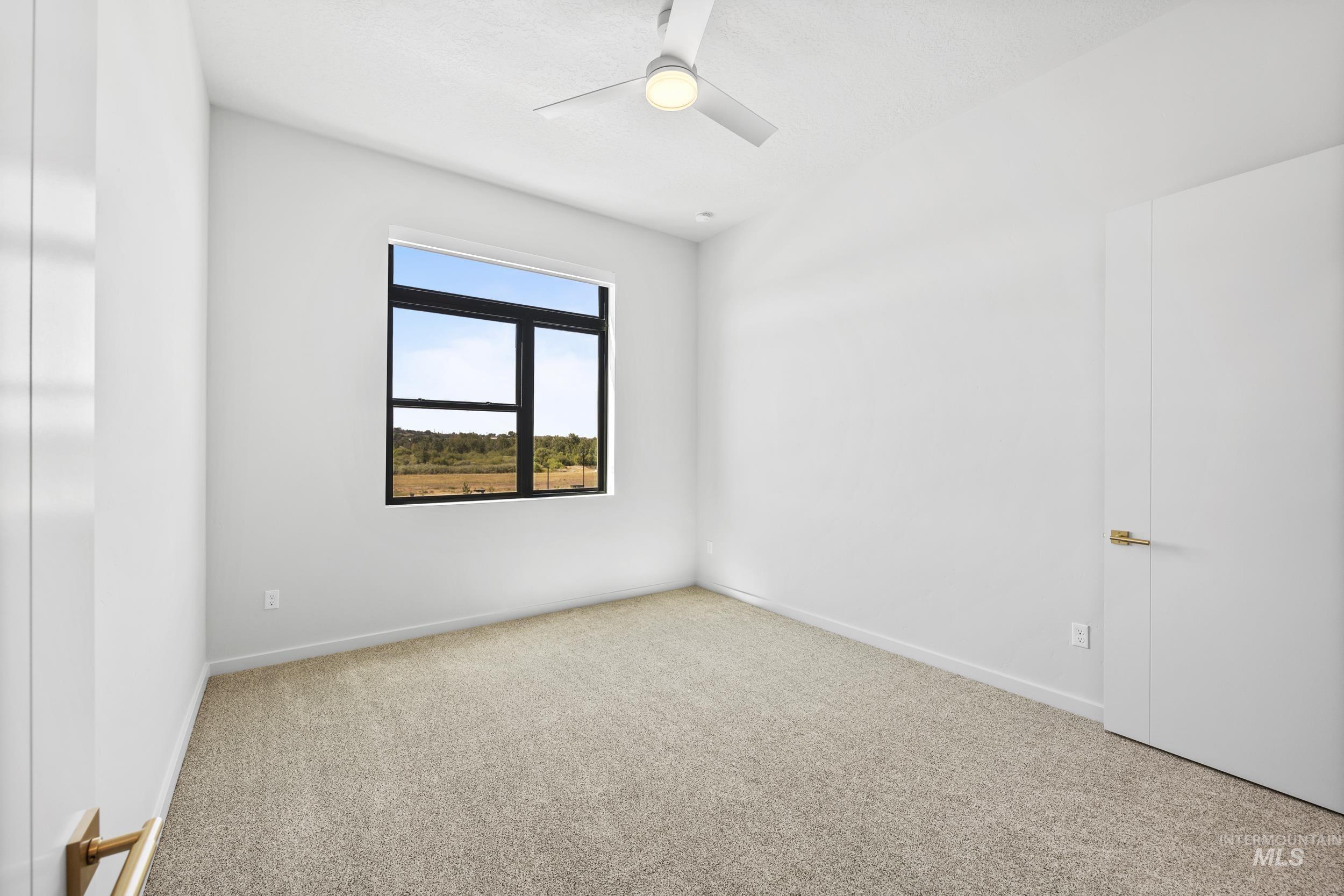 Empty room with carpet flooring and ceiling fan