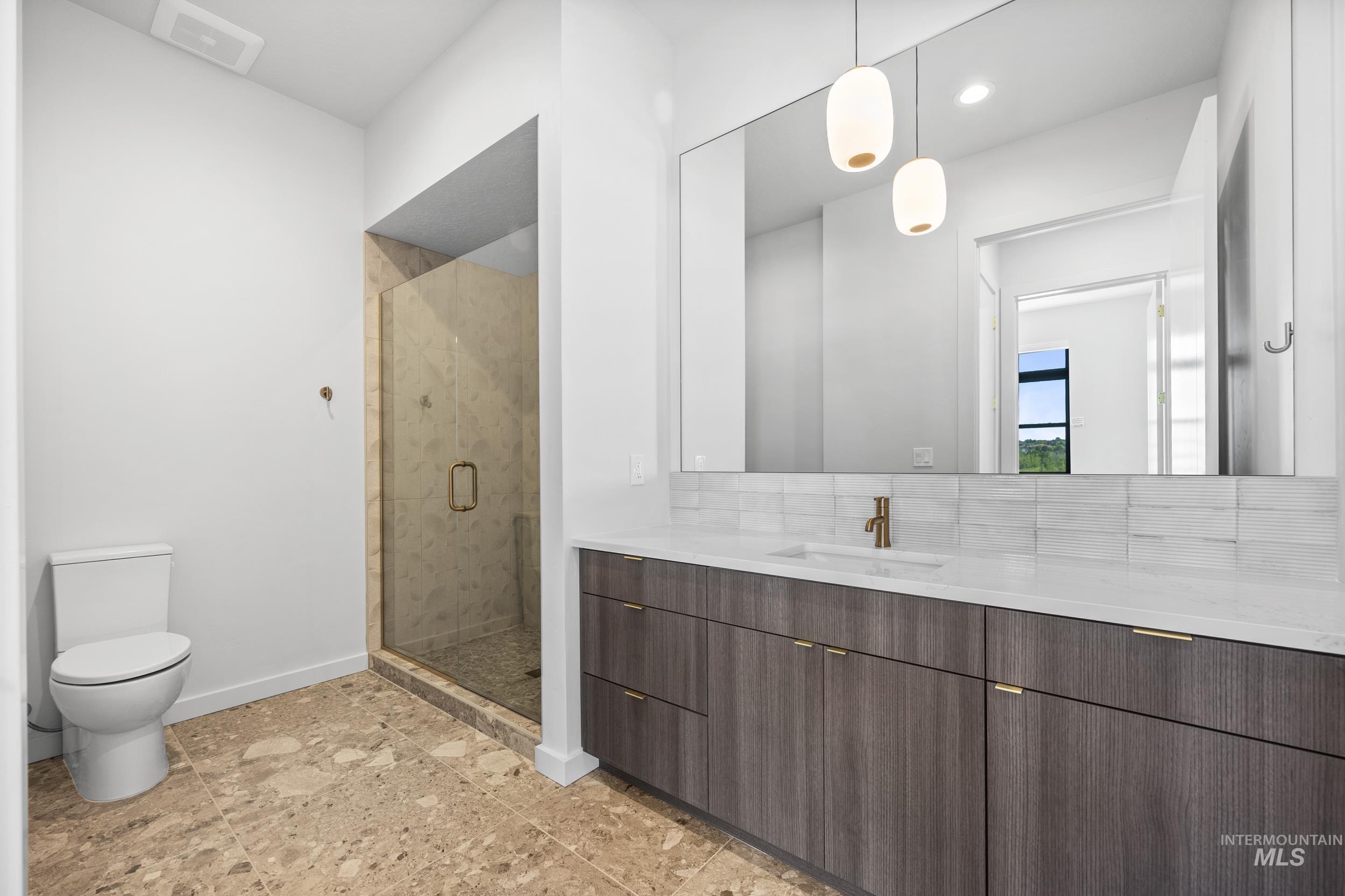 Bathroom featuring vanity, a shower stall, recessed lighting, and decorative backsplash
