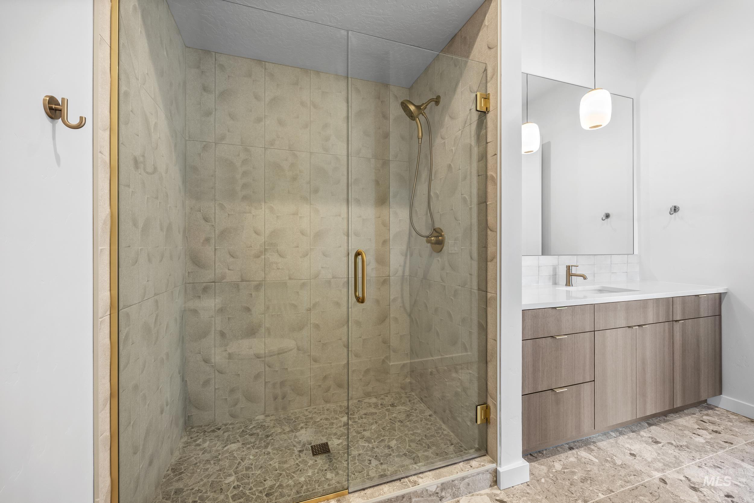 Bathroom with vanity, a stall shower, light tile patterned flooring, and tasteful backsplash