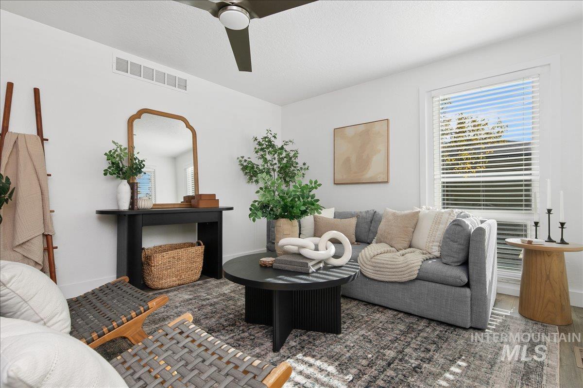 Living area featuring plenty of natural light, ceiling fan, and a textured ceiling