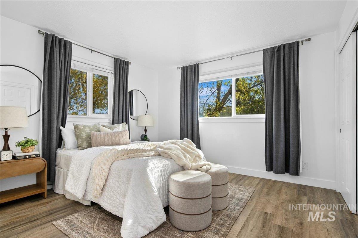 Bedroom with wood finished floors and a closet