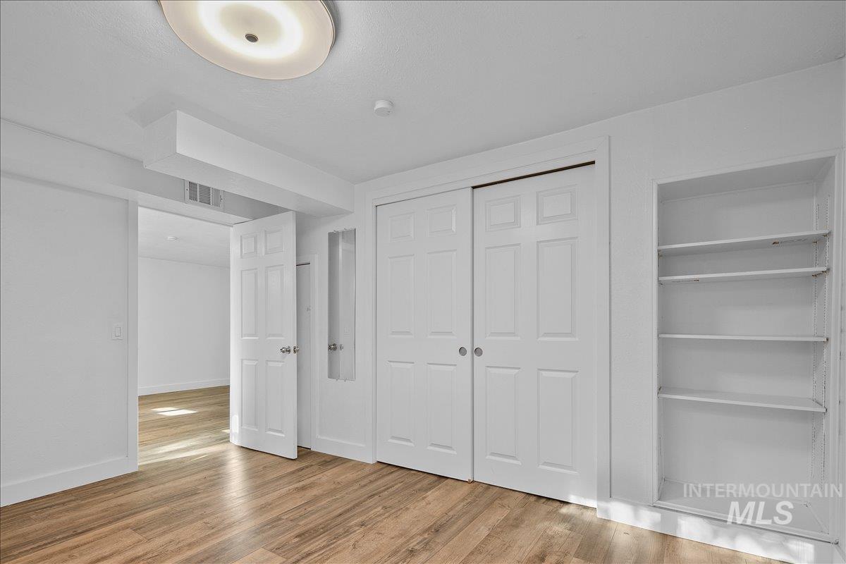 Unfurnished bedroom featuring light wood-type flooring and a closet