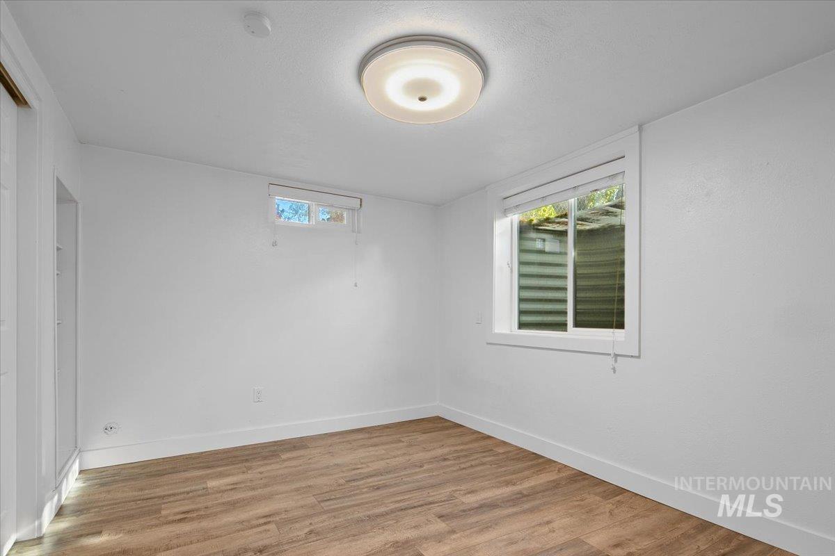 Spare room featuring light wood-style flooring and baseboards