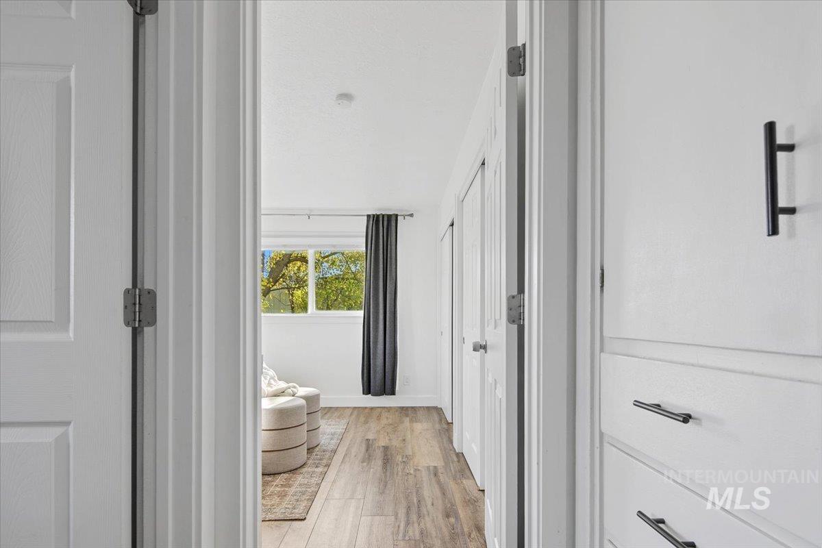Hallway featuring light wood-style floors and baseboards