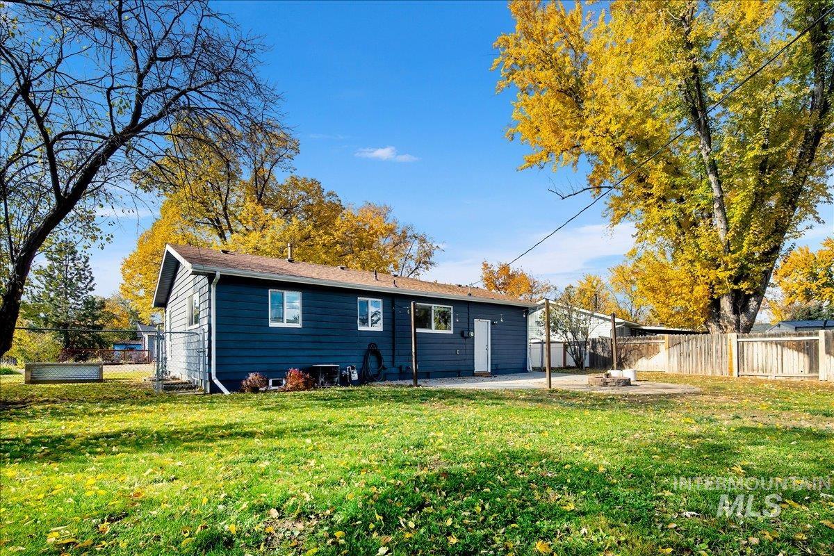 Rear view of house with a fenced backyard and a patio area