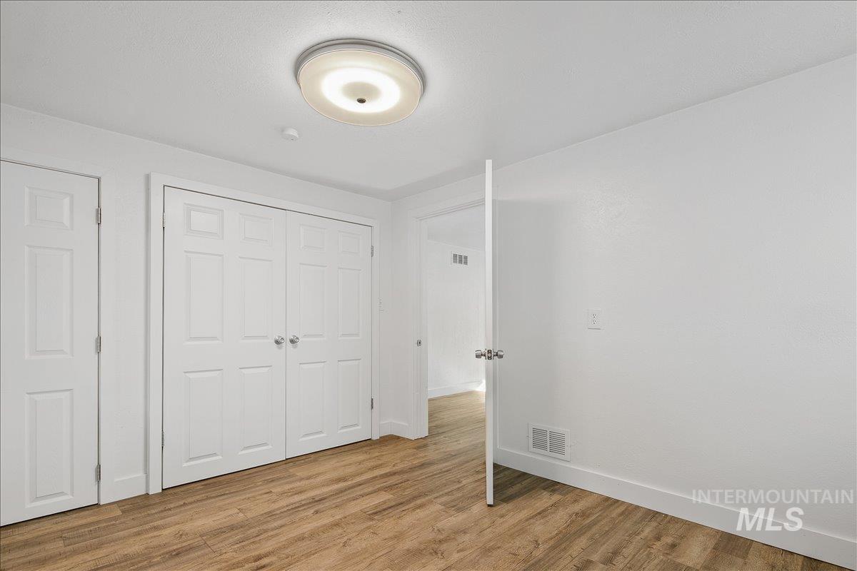 Unfurnished bedroom featuring light wood-type flooring and a closet