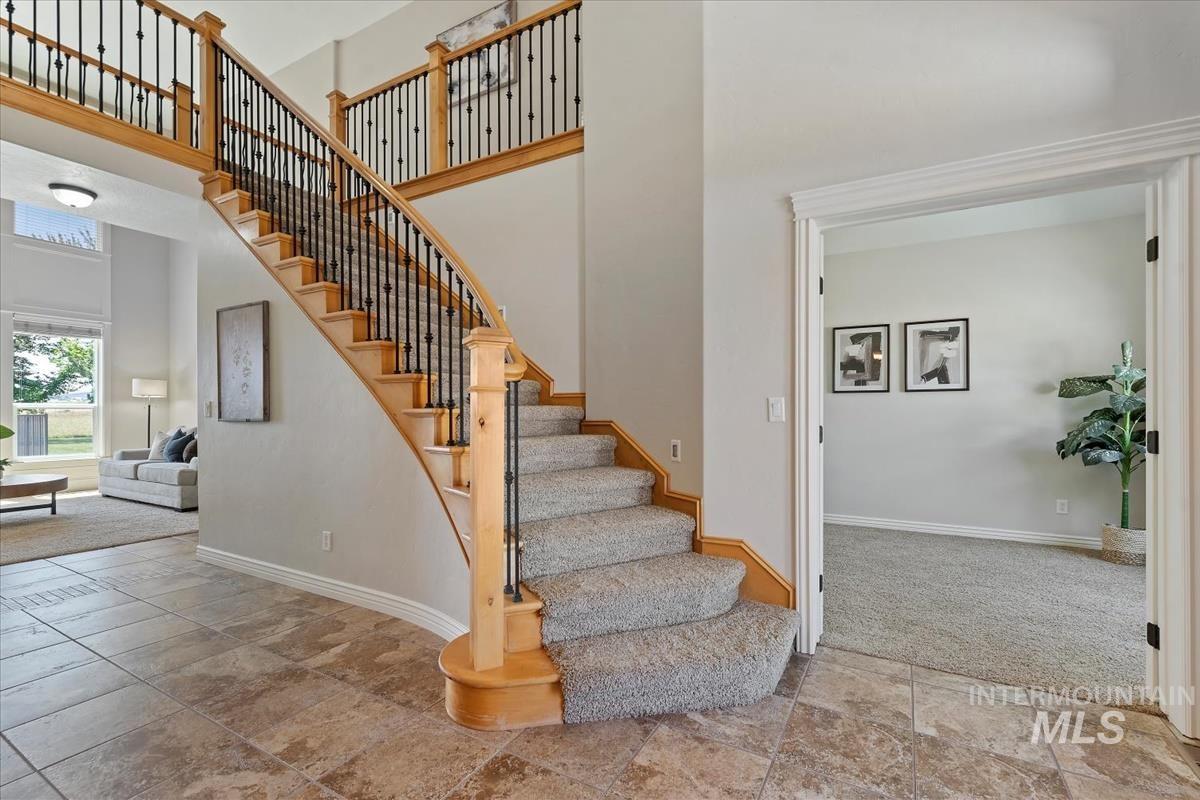Grand entryway featuring a curved staircase with natural wood handrails and wrought iron balusters