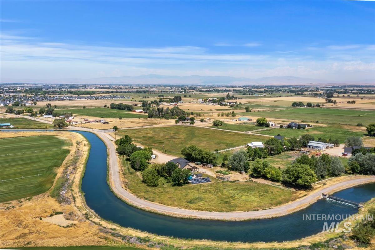 Aerial perspective showcasing extensive acreage with agricultural fields and scattered residential properties