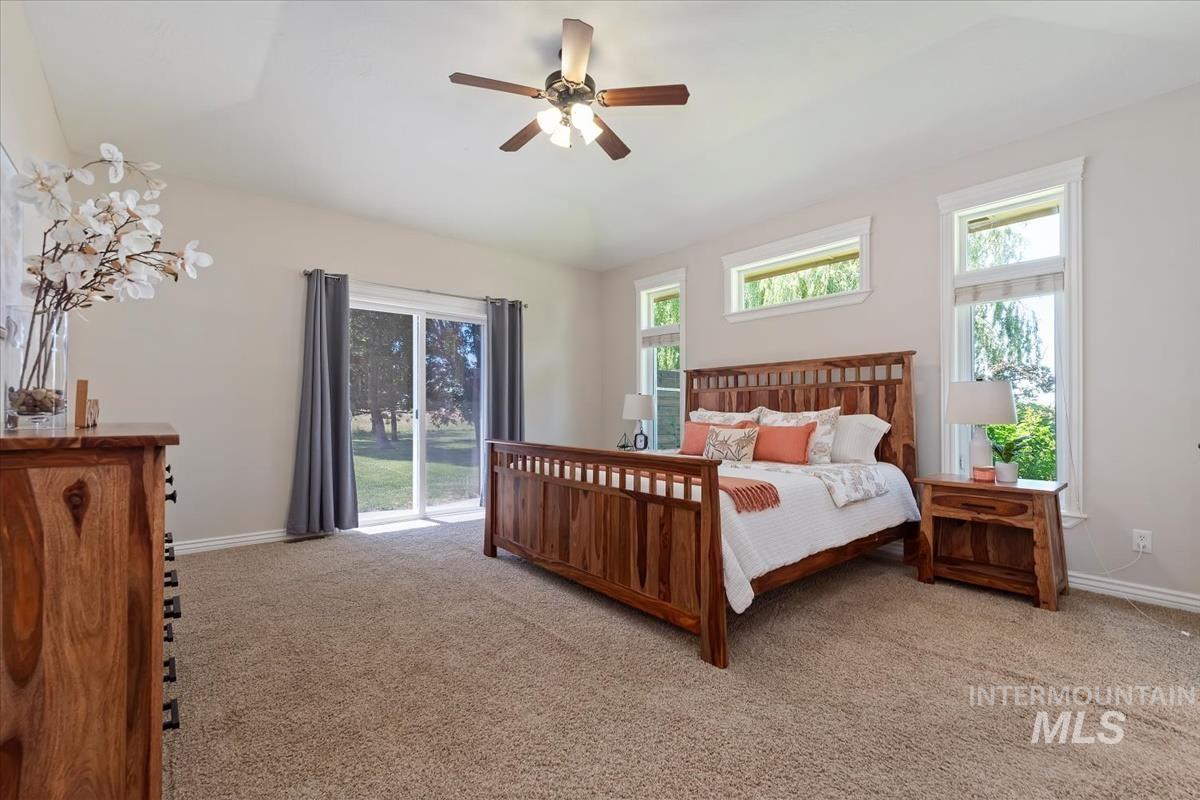 Carpeted room featuring a vaulted ceiling and a ceiling fan