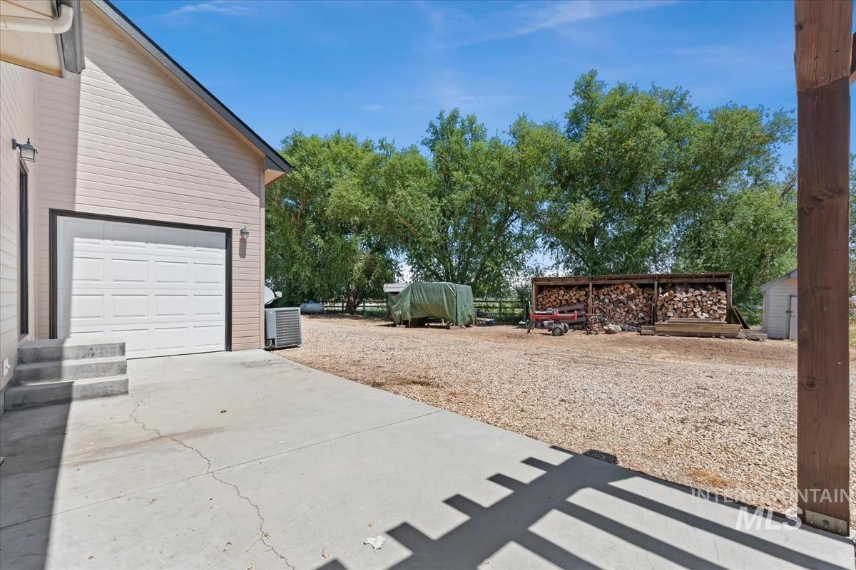 Attached two-car garage with a white panel door, concrete driveway, and exterior lighting fixtures