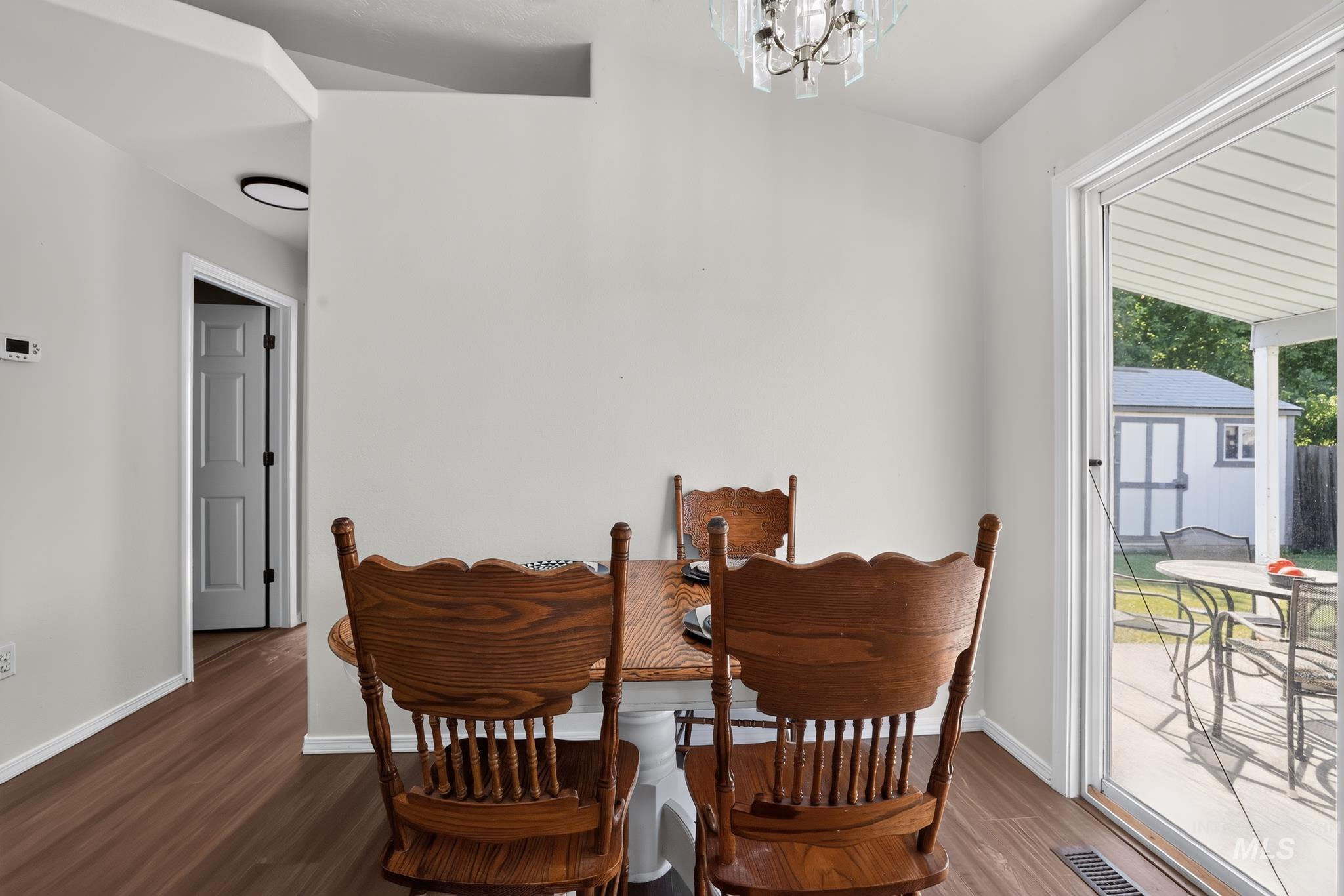 Wood-finish flooring throughout, bright white walls, and a contemporary ceiling light fixture