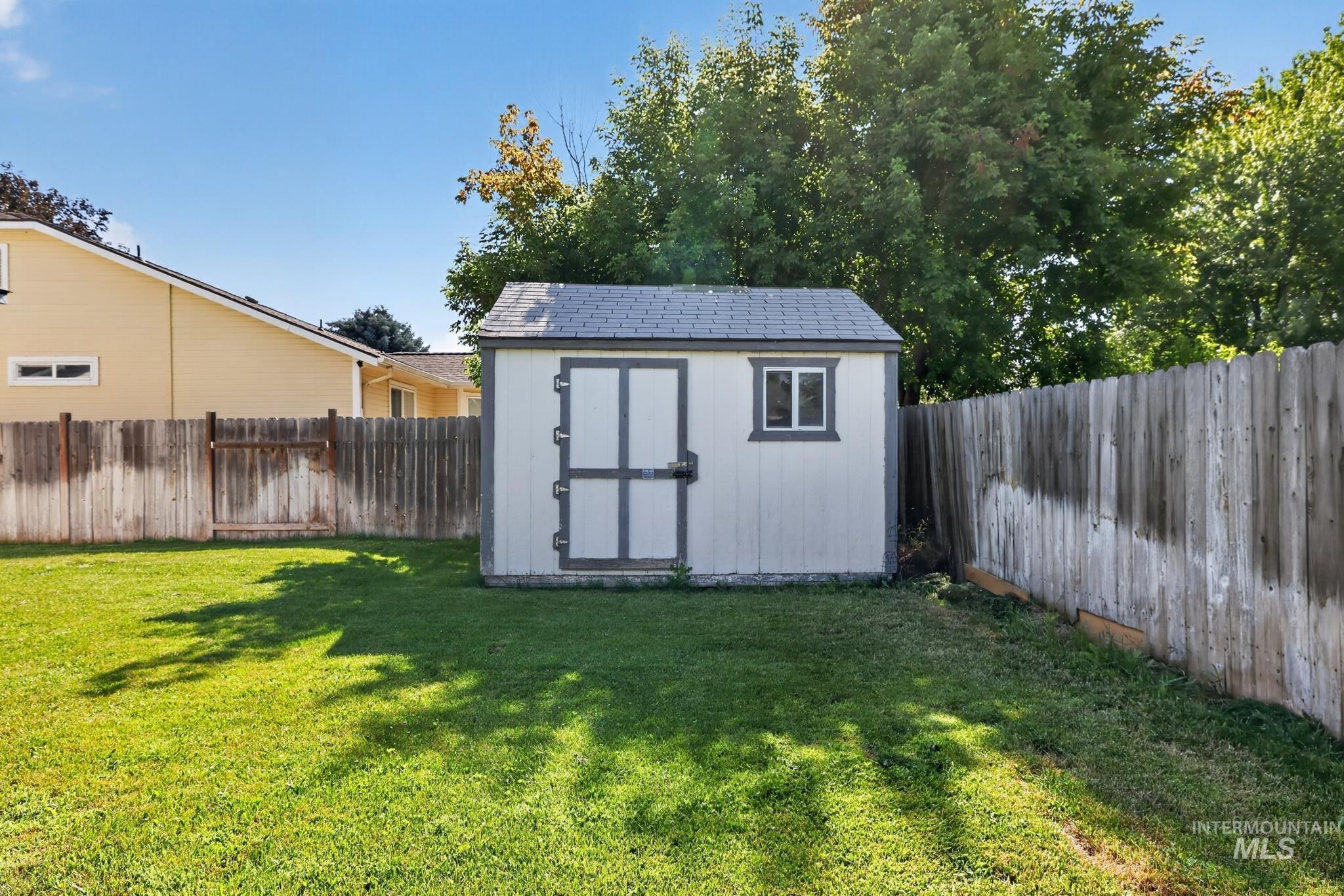 Storage shed with a shingled roof and double doors