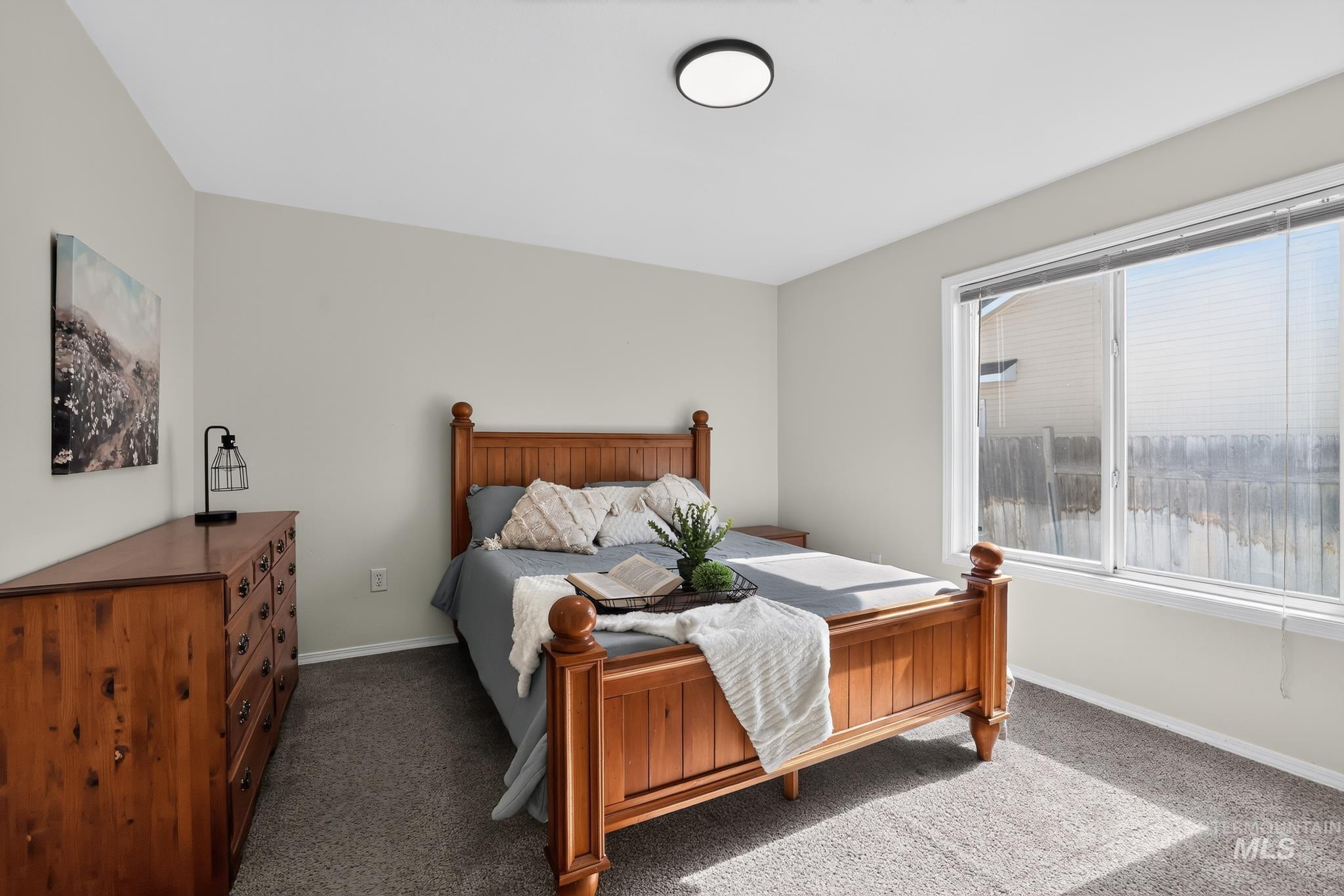 Carpeted bedroom featuring neutral wall paint and a flush-mount ceiling light