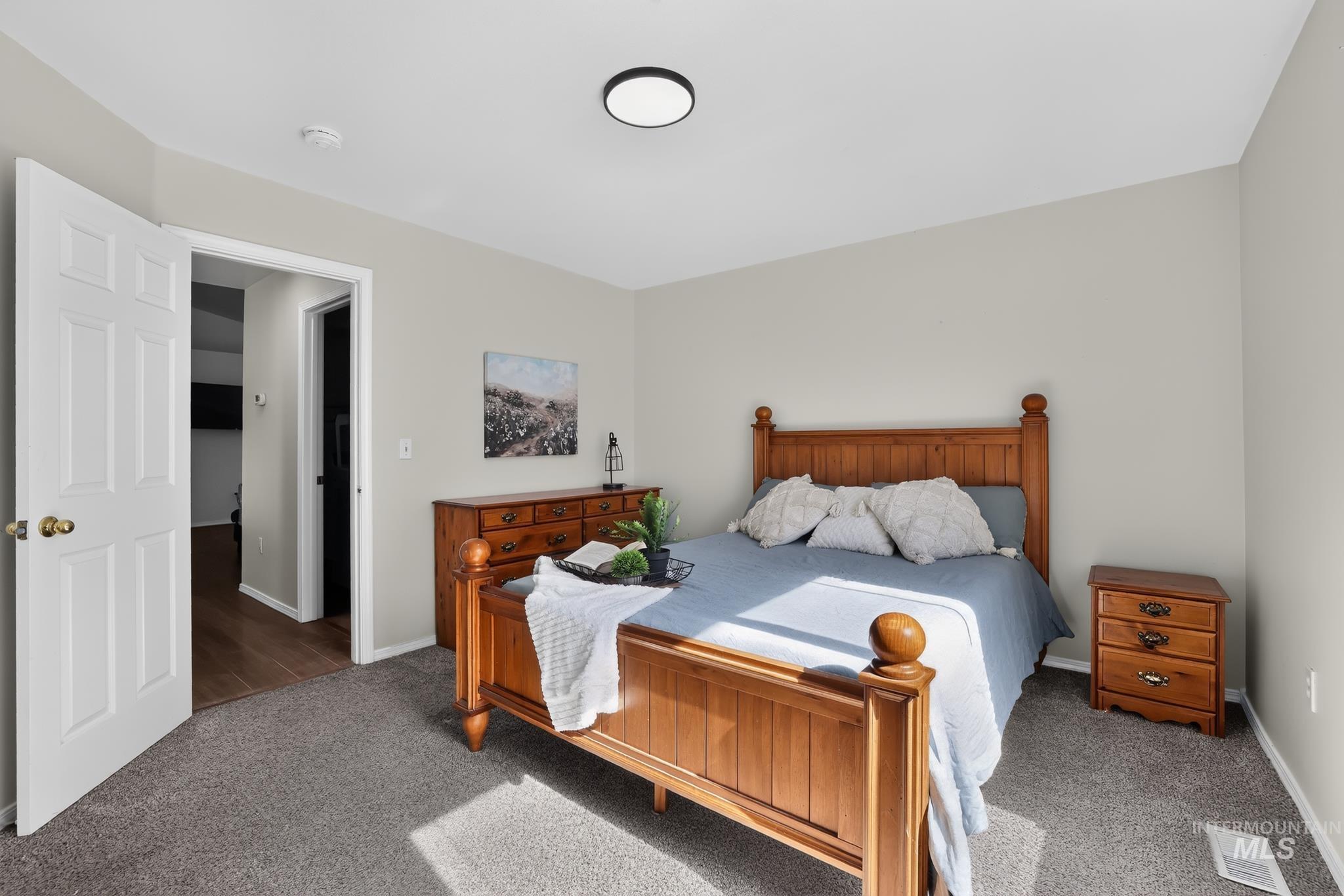 Carpeted bedroom with neutral wall tones and a flush-mount ceiling light fixture