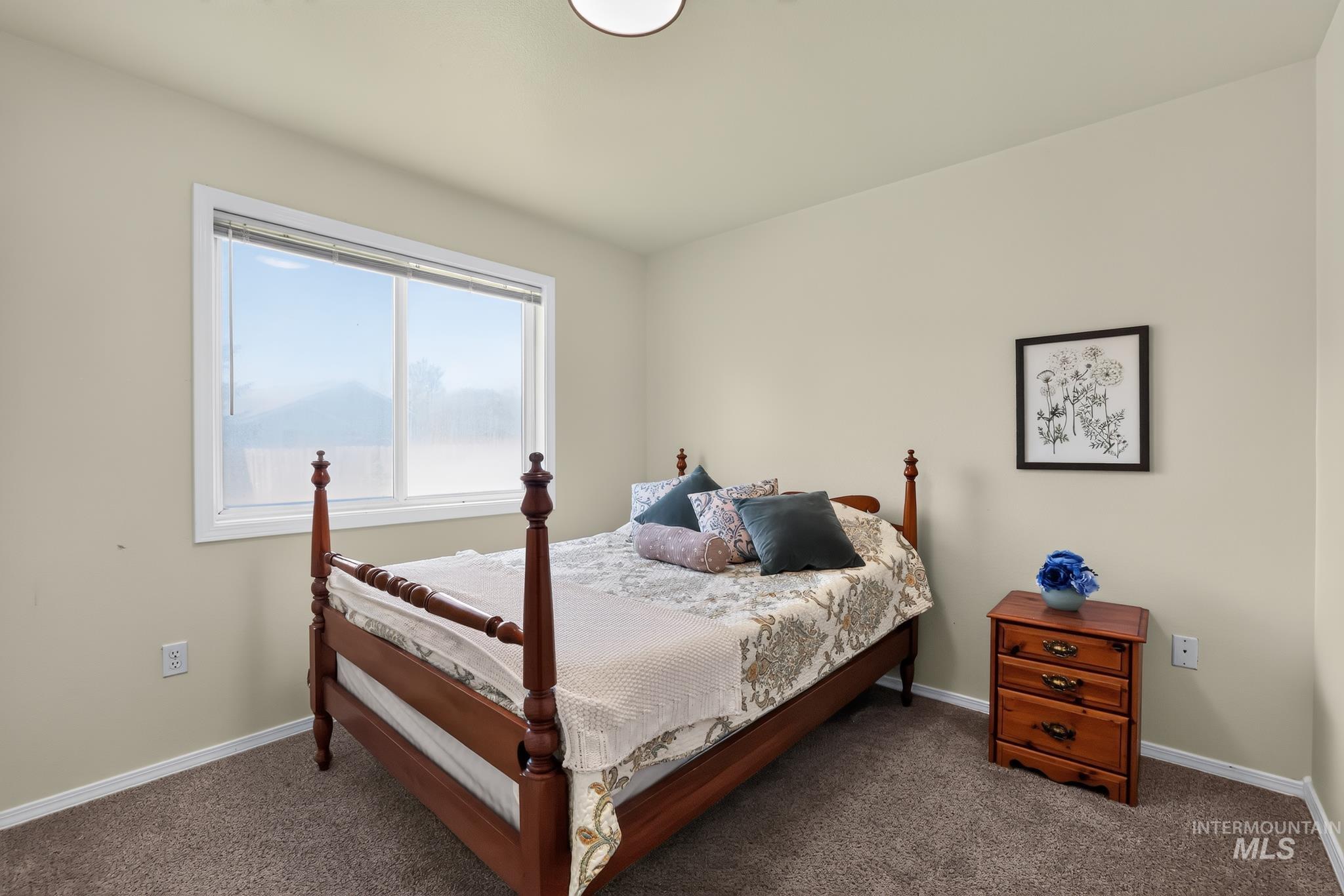 Light-toned walls with contrasting white trim, neutral carpet flooring, and a ceiling-mounted light fixture