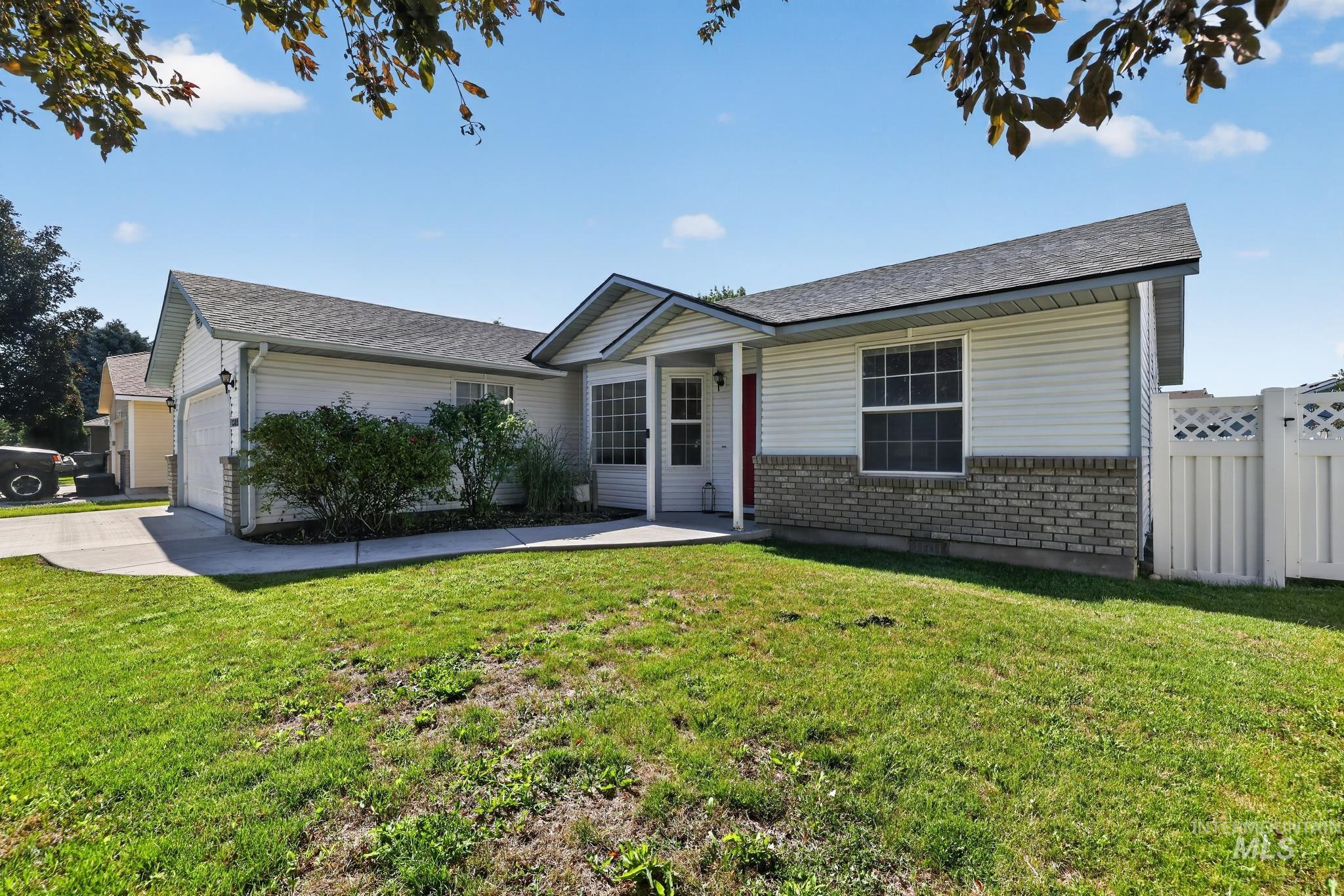 Single-story home featuring a covered entry, white vinyl siding, and brick accent detailing