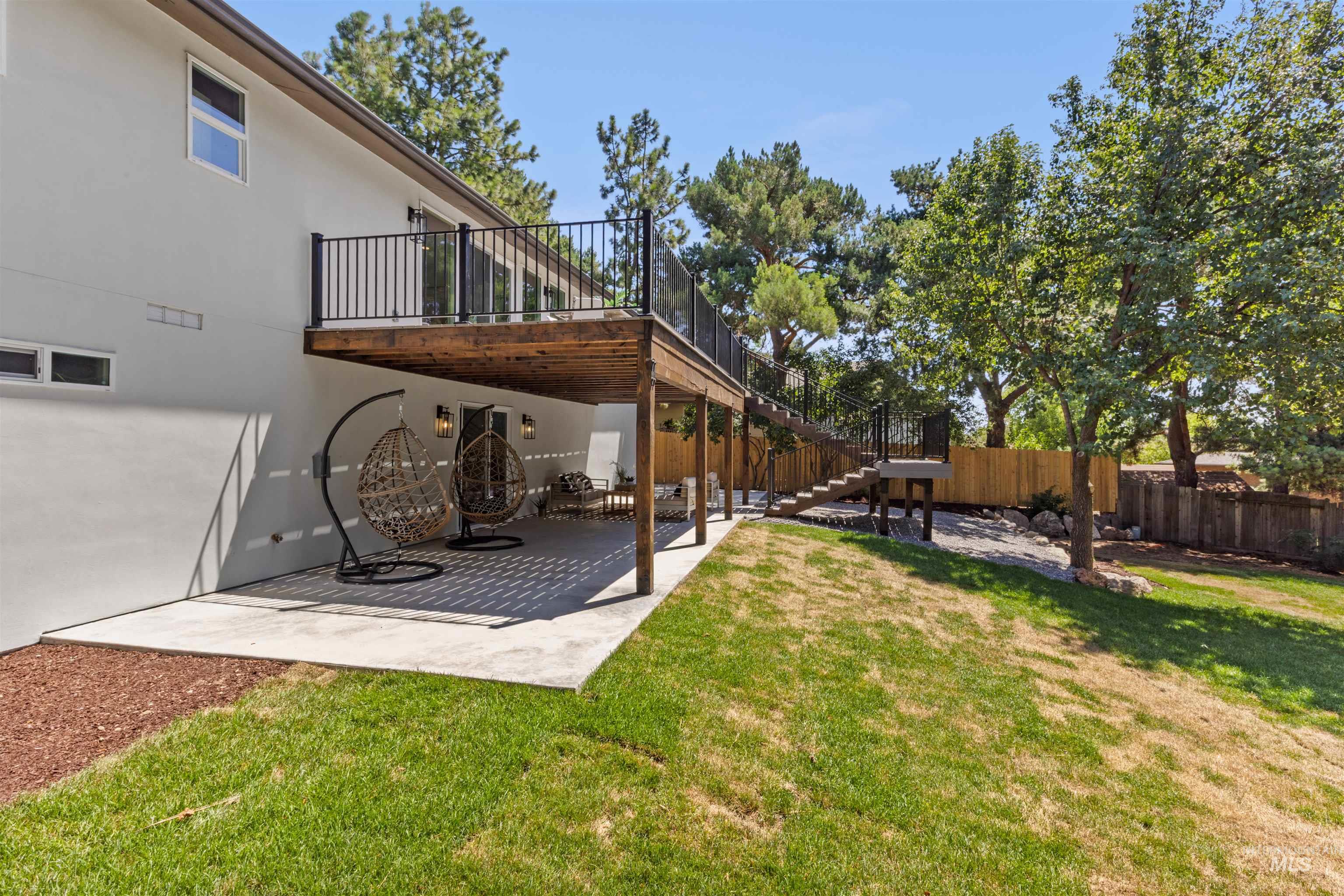 View of yard featuring stairs, a patio area, and a wooden deck