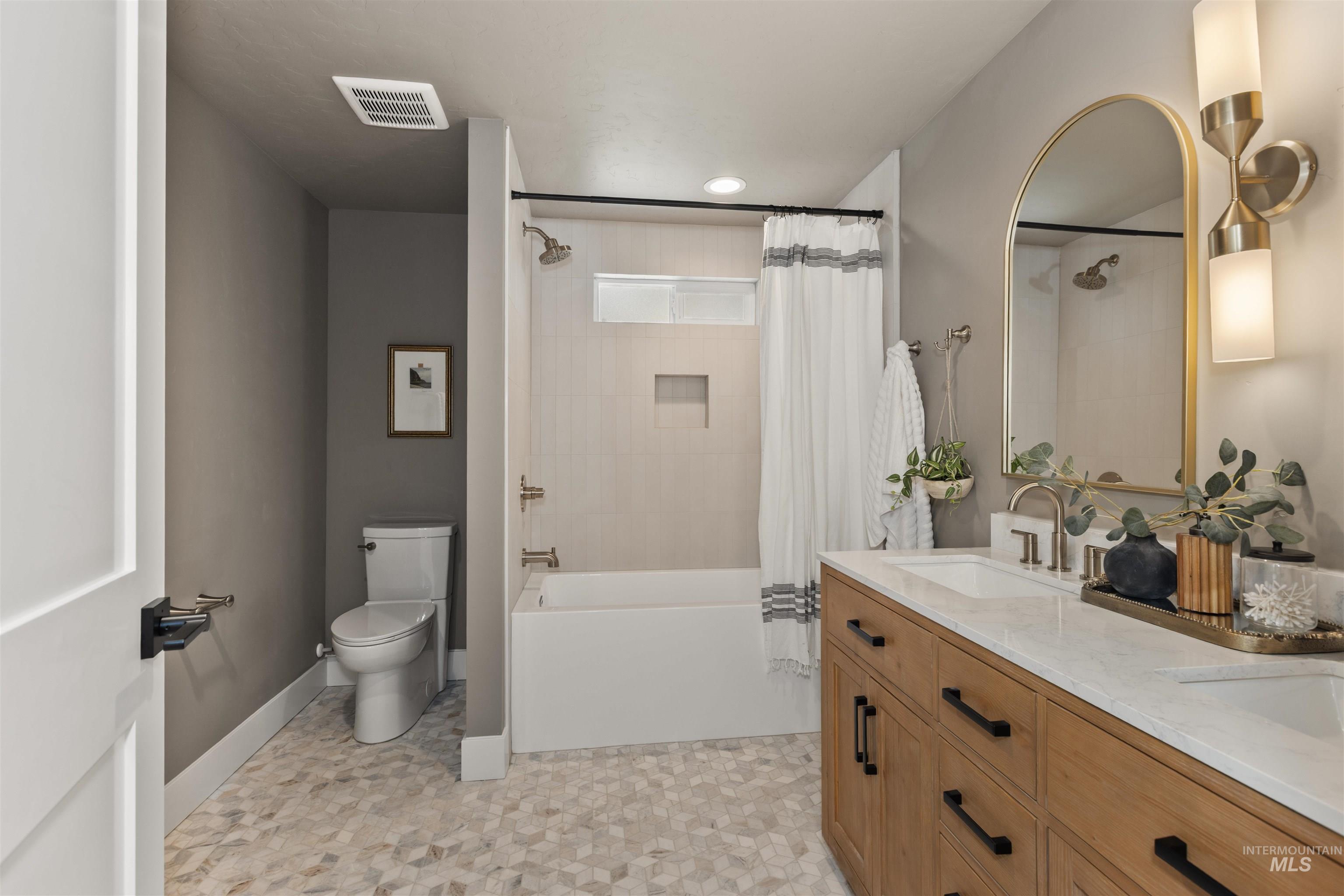 Full bath featuring shower / tub combo and double vanity