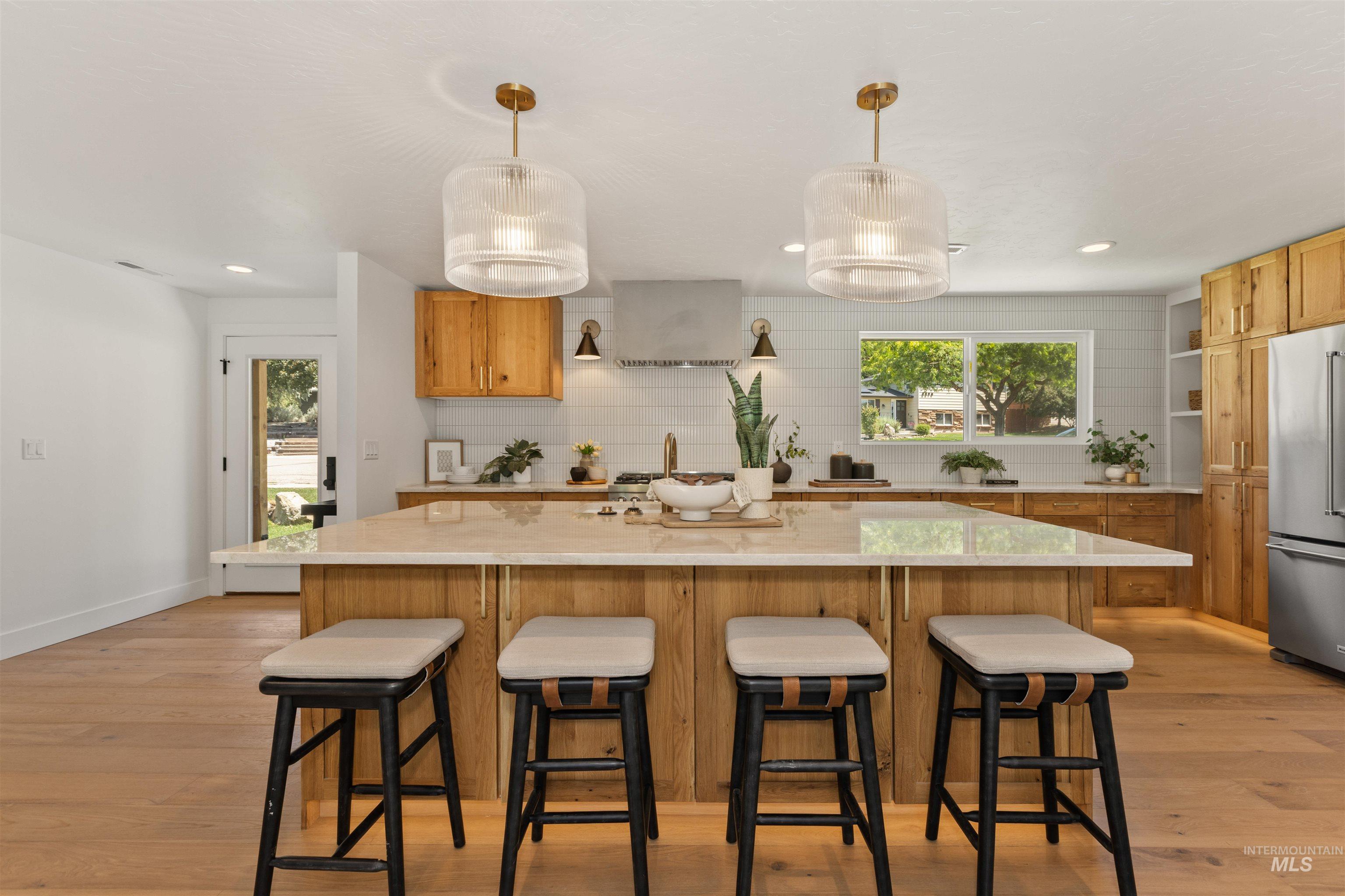 Kitchen featuring decorative backsplash, pendant lighting, a breakfast bar area, recessed lighting, and healthy amount of natural light