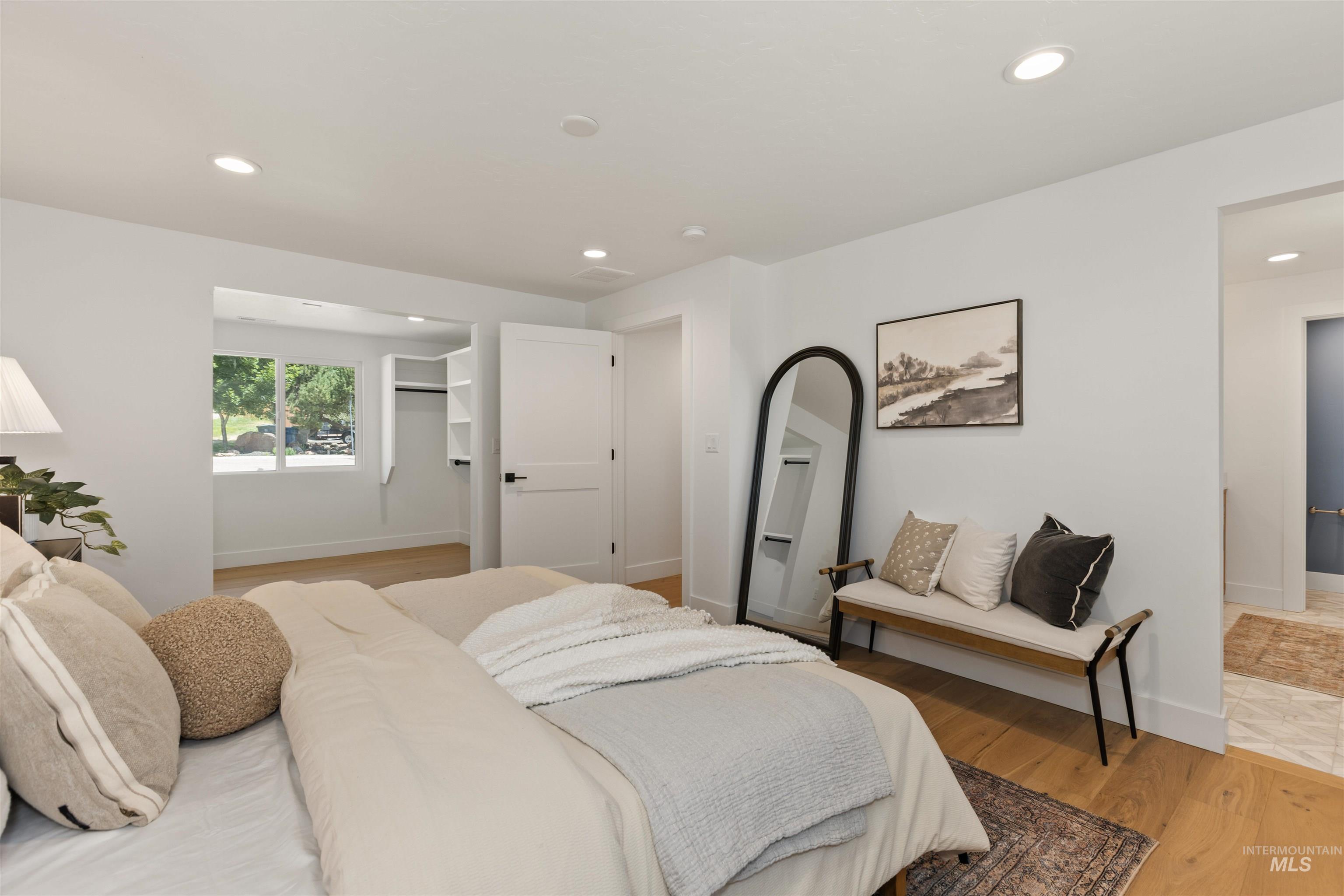 Bedroom featuring light wood-style floors, a walk in closet, and recessed lighting