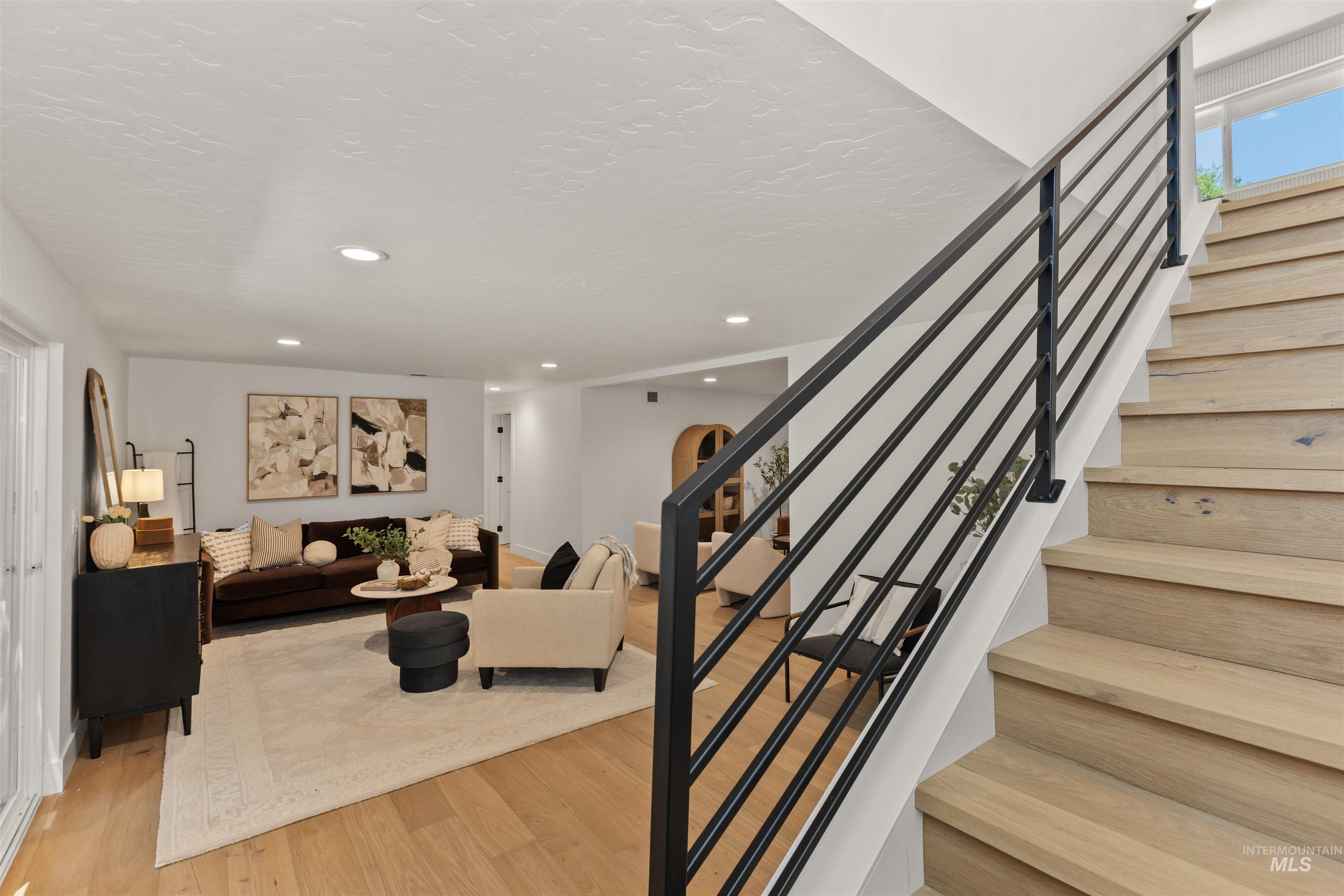 Stairway featuring wood finished floors and recessed lighting