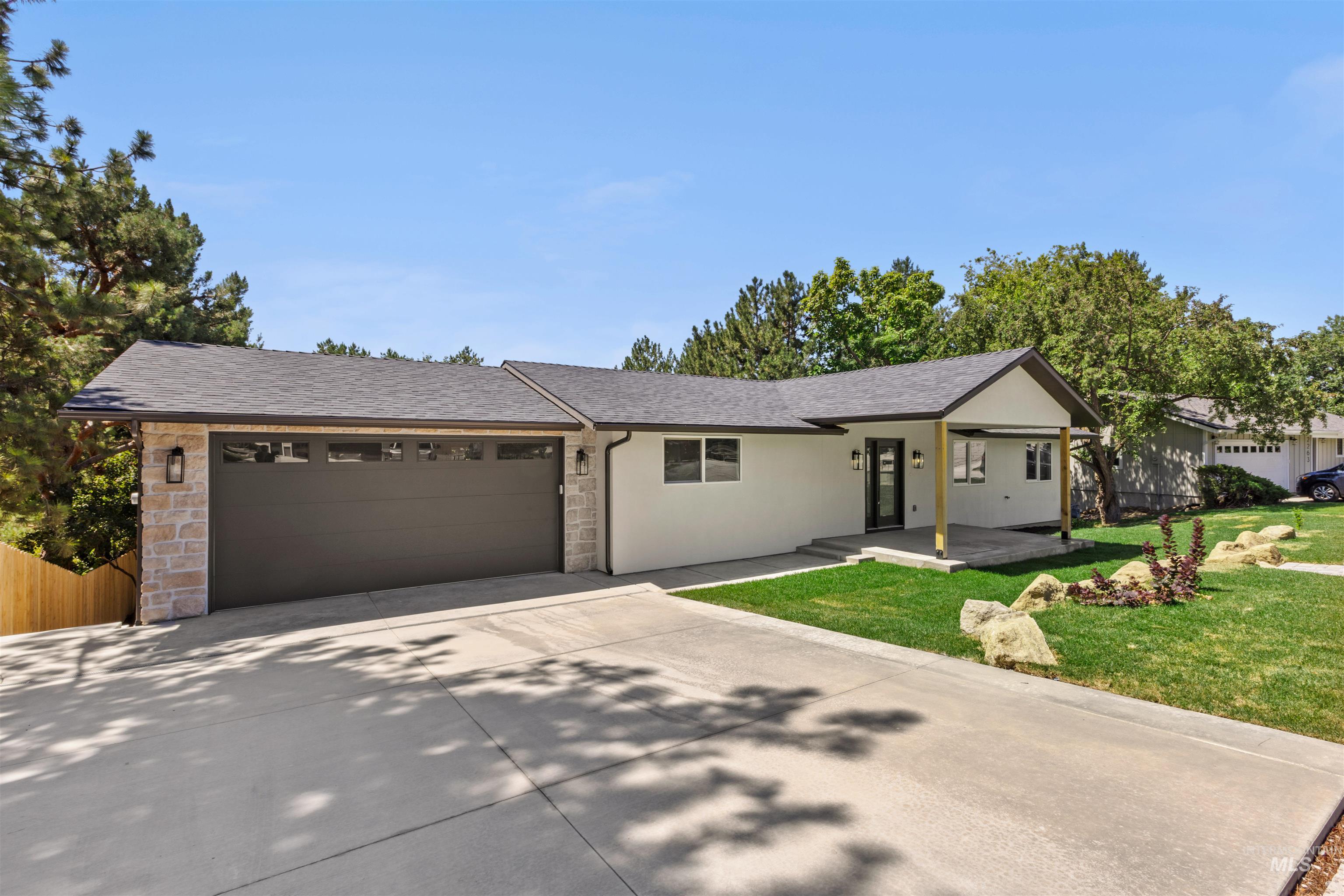 Ranch-style house with roof with shingles, concrete driveway, an attached garage, and a front yard