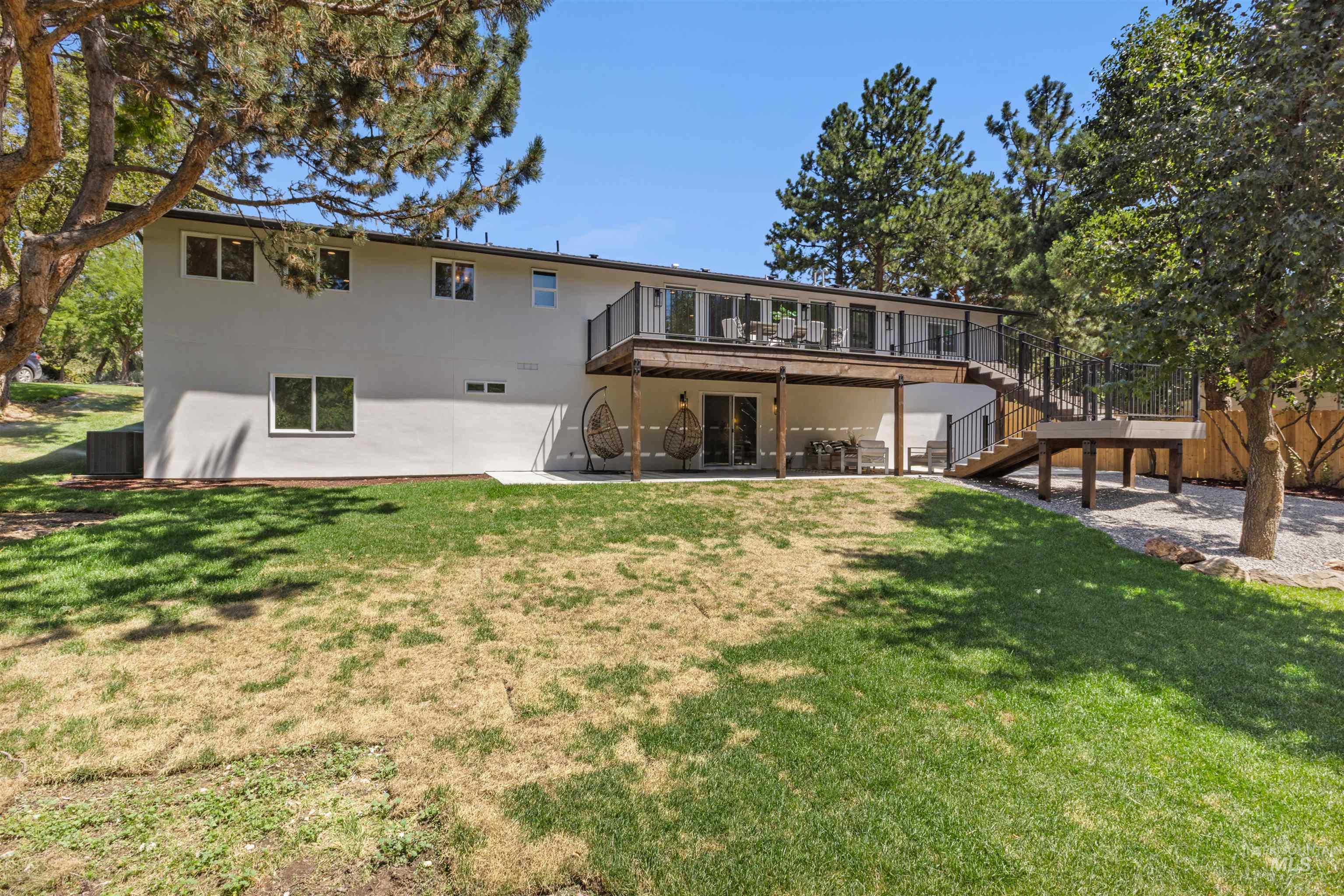 Back of house with a patio area, stairway, a wooden deck, and a lawn
