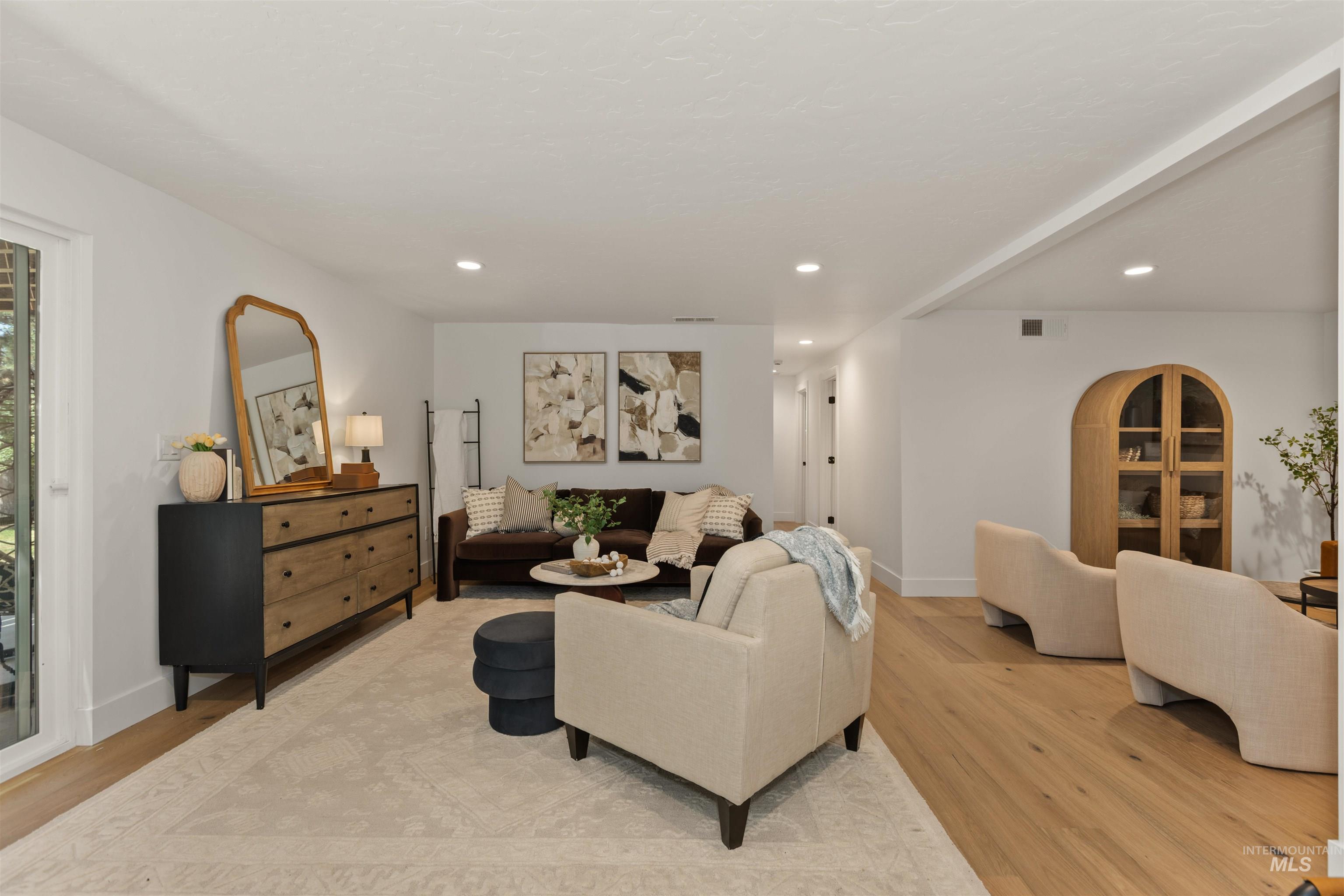 Living room with light wood-style floors and recessed lighting