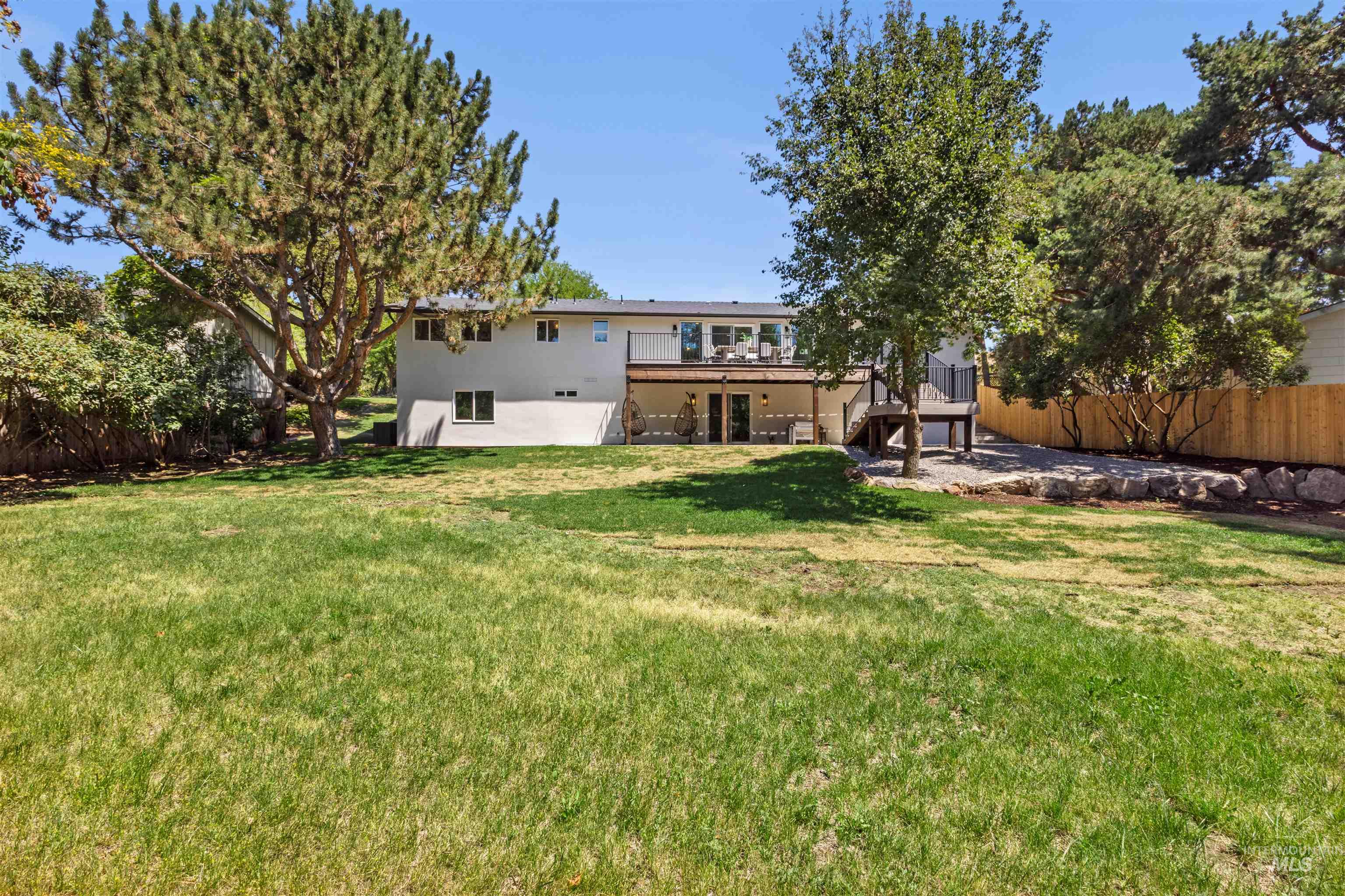 Rear view of property with a patio area, stairs, a deck, and stucco siding