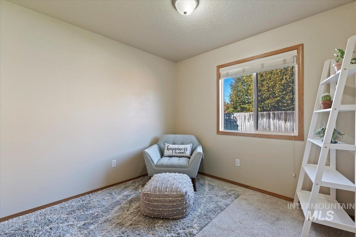 Living area featuring carpet and a textured ceiling