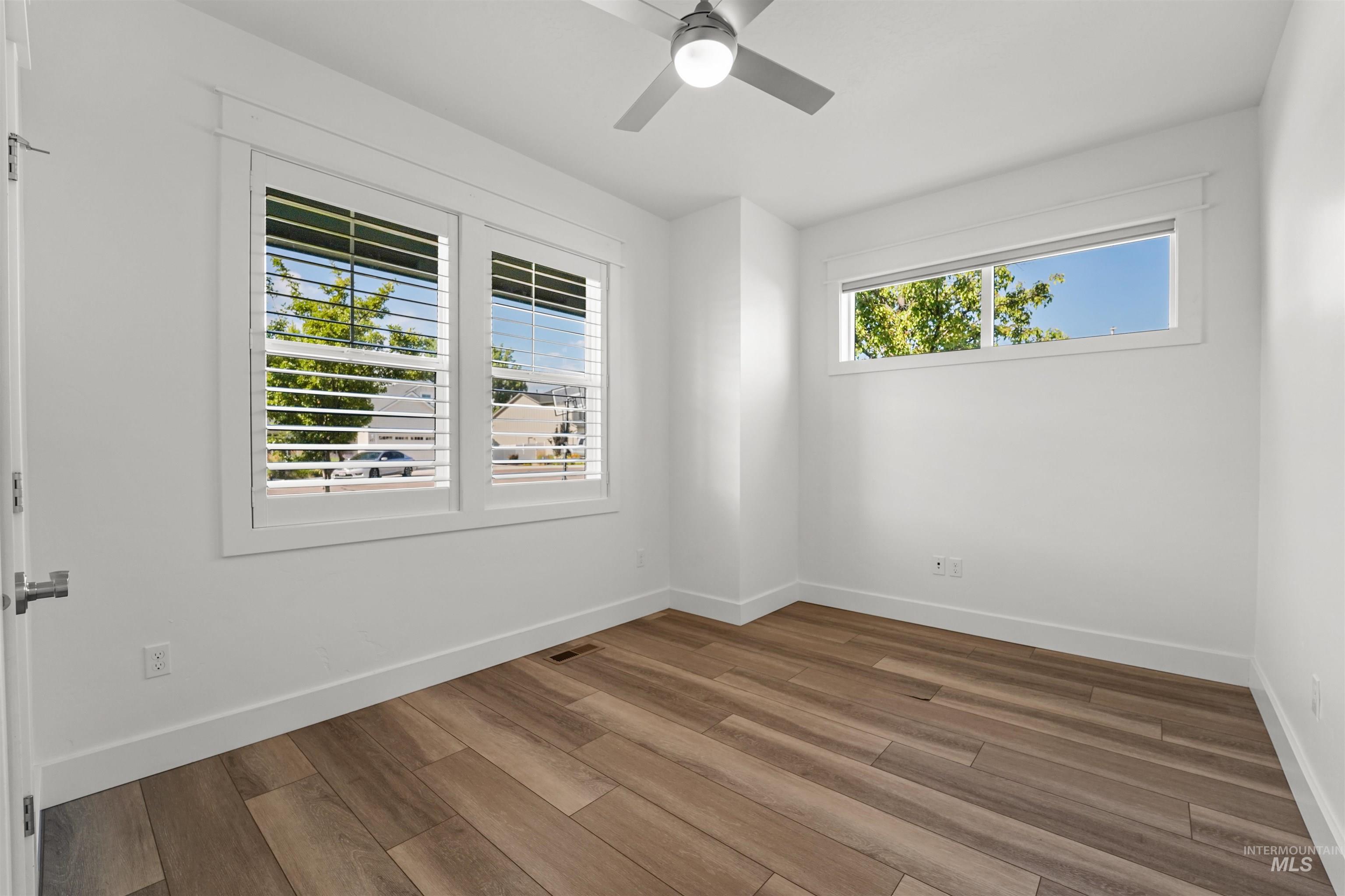 Spare room with wood finished floors and ceiling fan